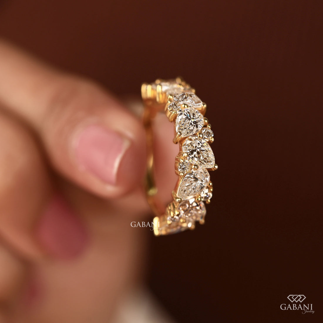 Pear and round lab grown diamond half eternity wedding band in yellow gold with alternating prong set diamond design.