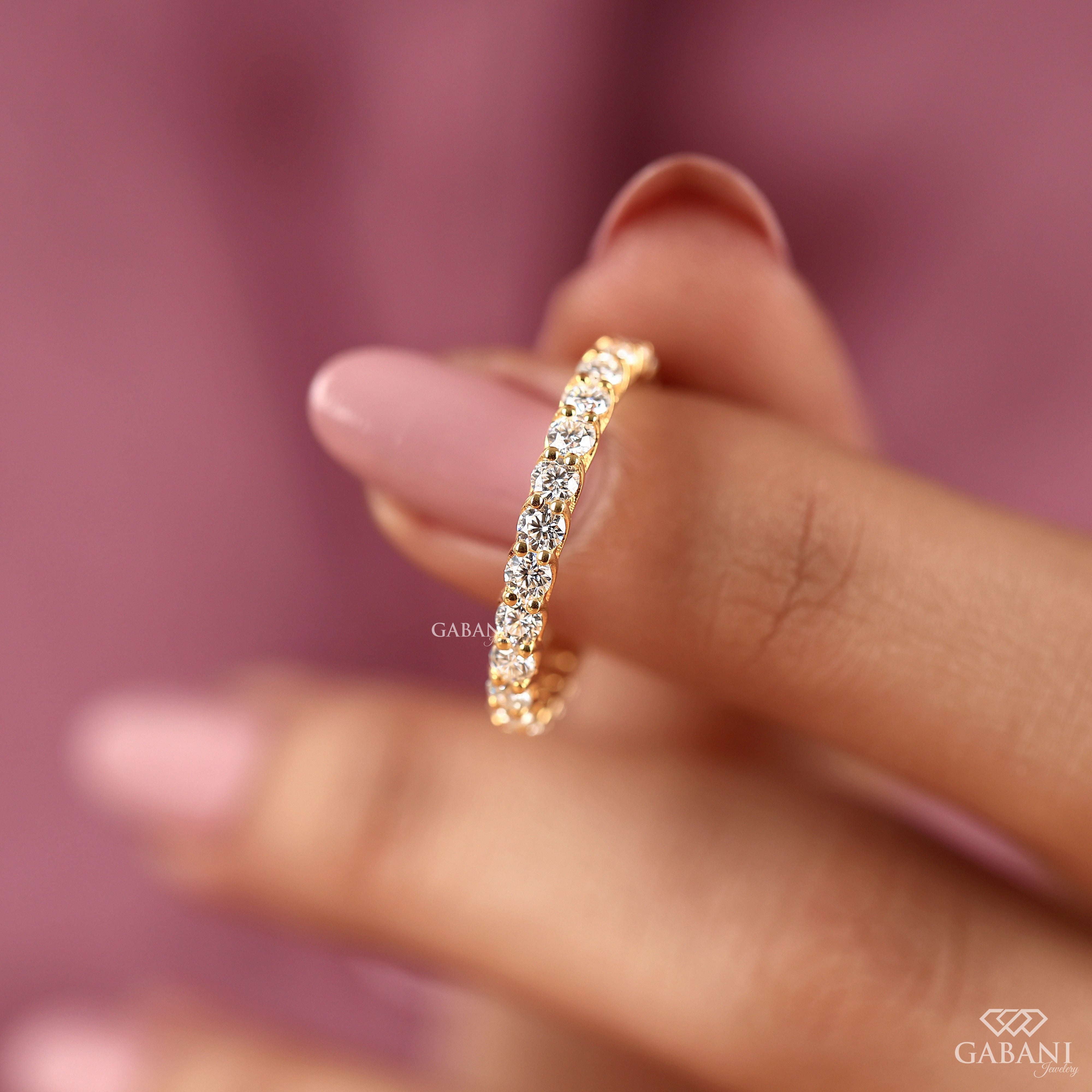 a round lab grown diamond full eternity band in 14K yellow gold, featuring sparkling shared prong set diamonds in a classic wedding band design by Gabani Jewelry.