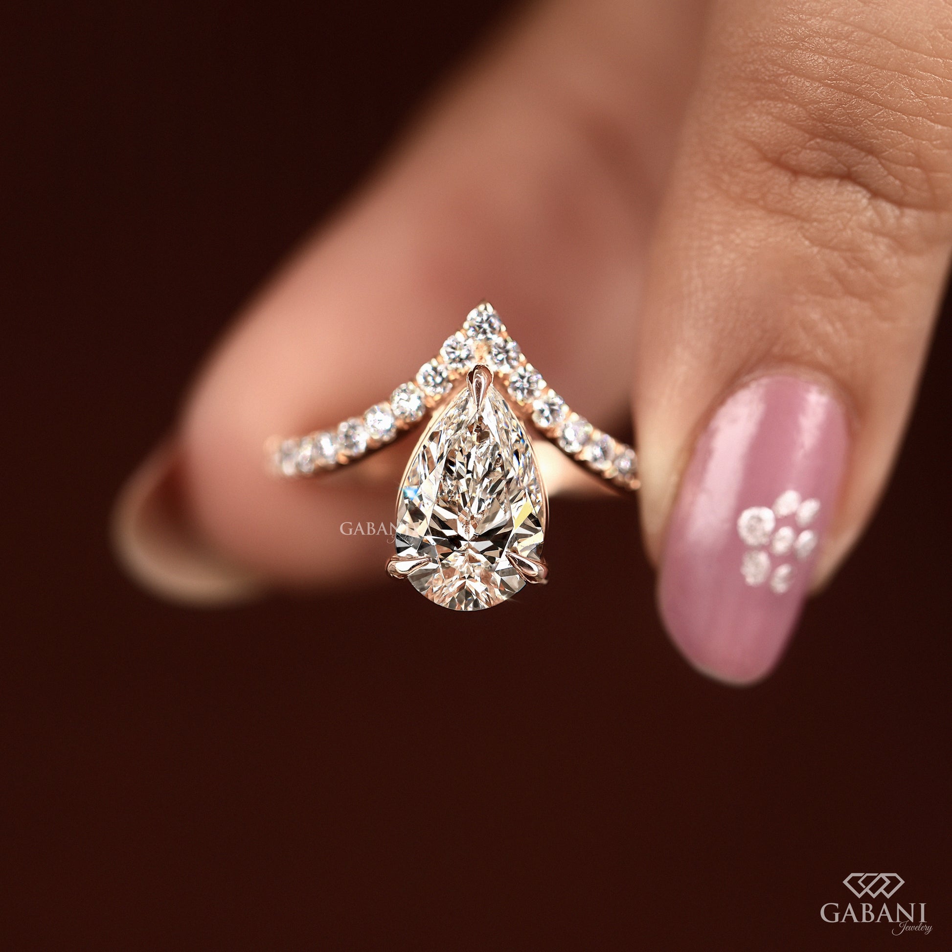 V shaped rose gold ring with pear lab grown diamond and side stones