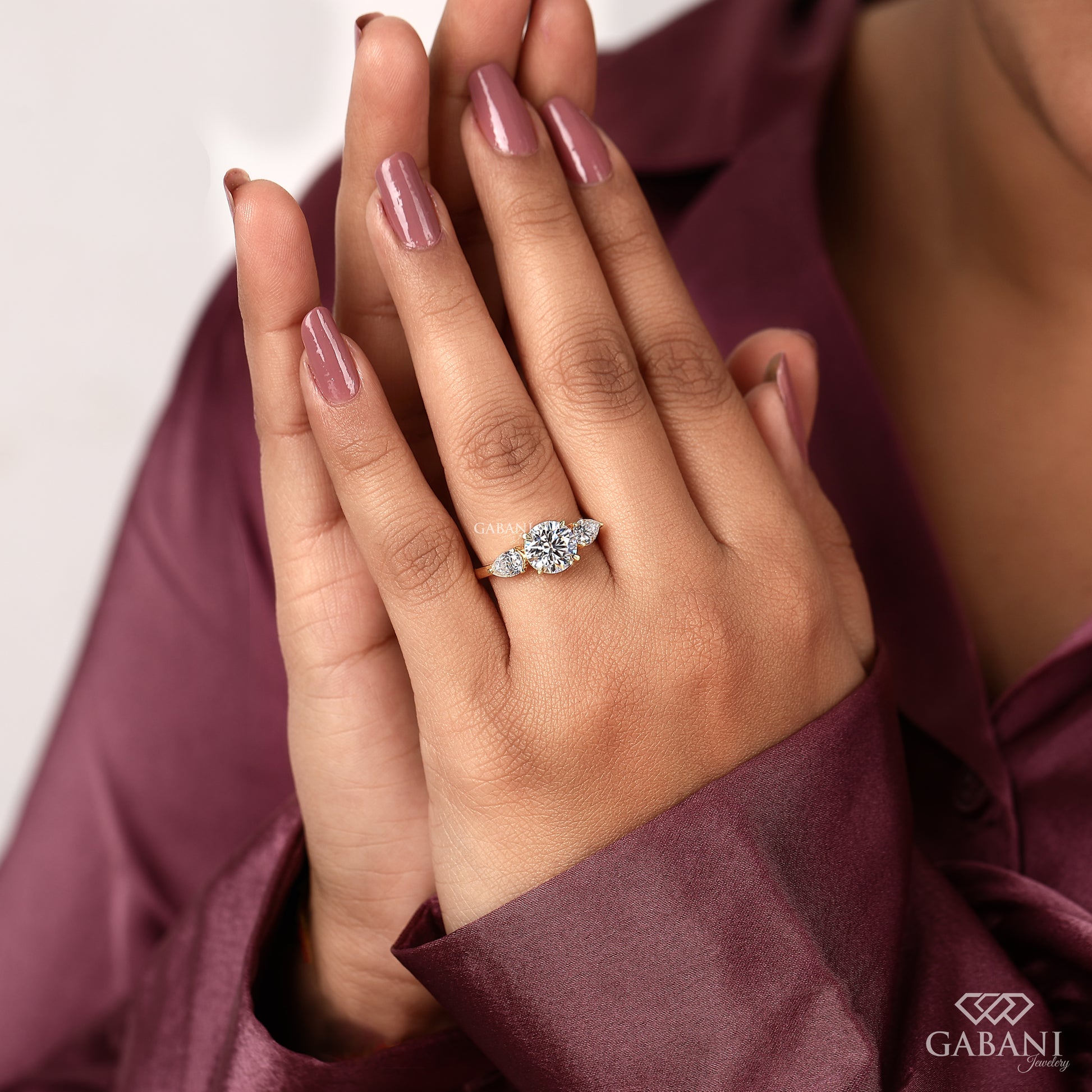 round cut lab grown diamond ring with pear side stones set in 14k yellow gold prong setting