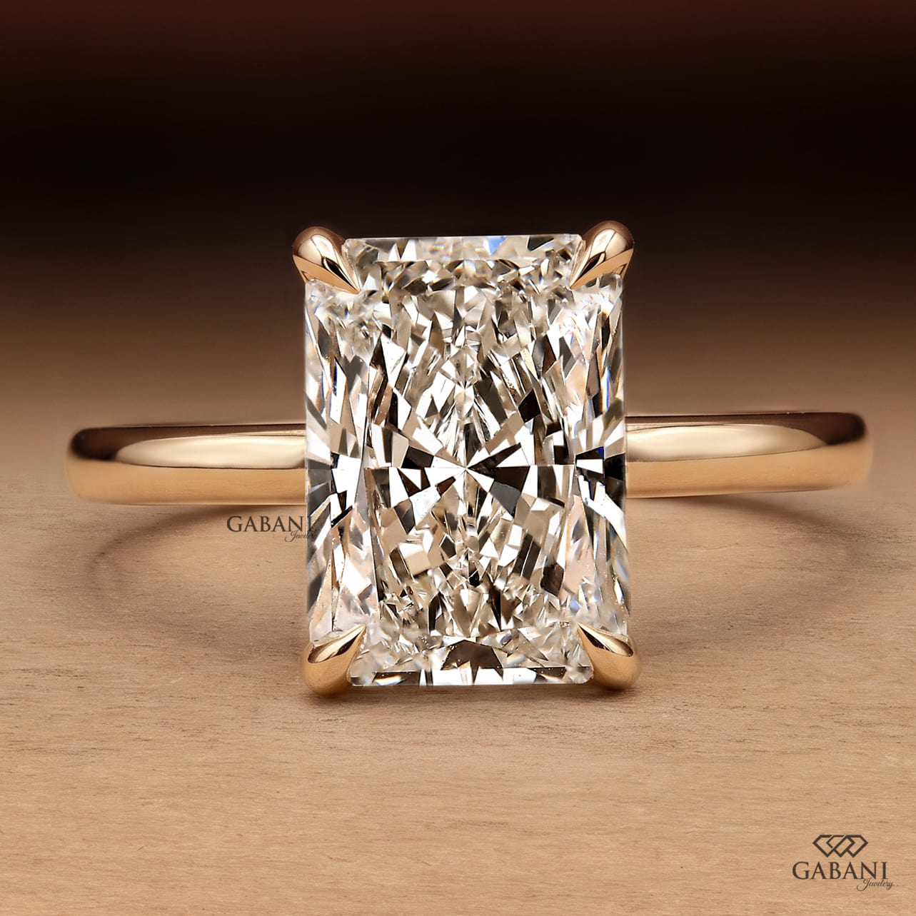 Radiant cut lab grown diamond engagement ring in 18K yellow gold with hidden halo, four claw prong setting and round diamond accents.
