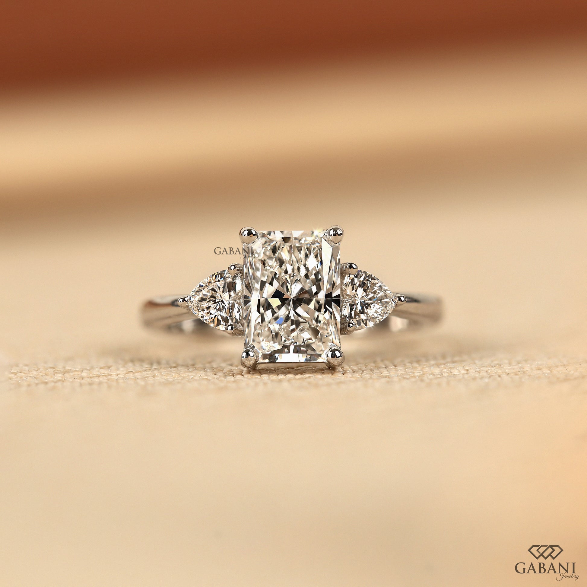 Radiant cut lab grown diamond three stone ring with heart side diamonds in solid white gold