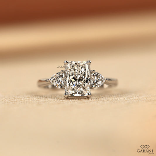 Radiant cut lab grown diamond three stone ring with heart side diamonds in solid white gold