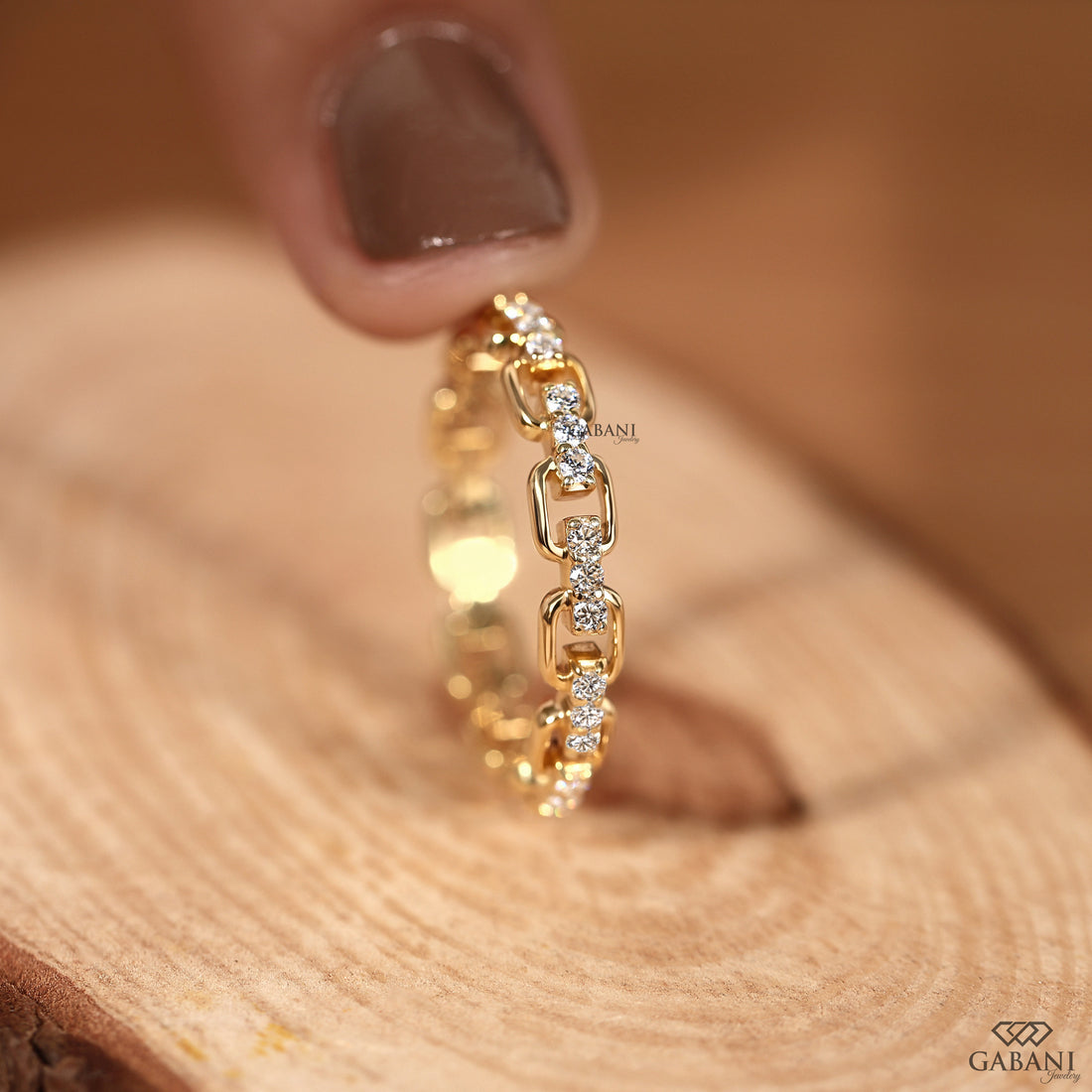 a round lab grown diamond chain link eternity band in 14K yellow gold, featuring prong set diamonds and rectangular gold links.