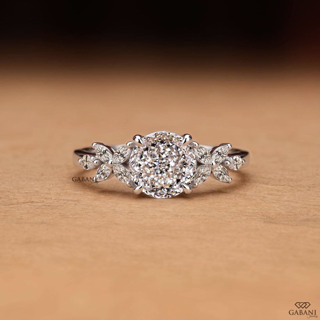 Round Portuguese cut lab grown diamond engagement ring with marquise leaf side stones in polished white gold.