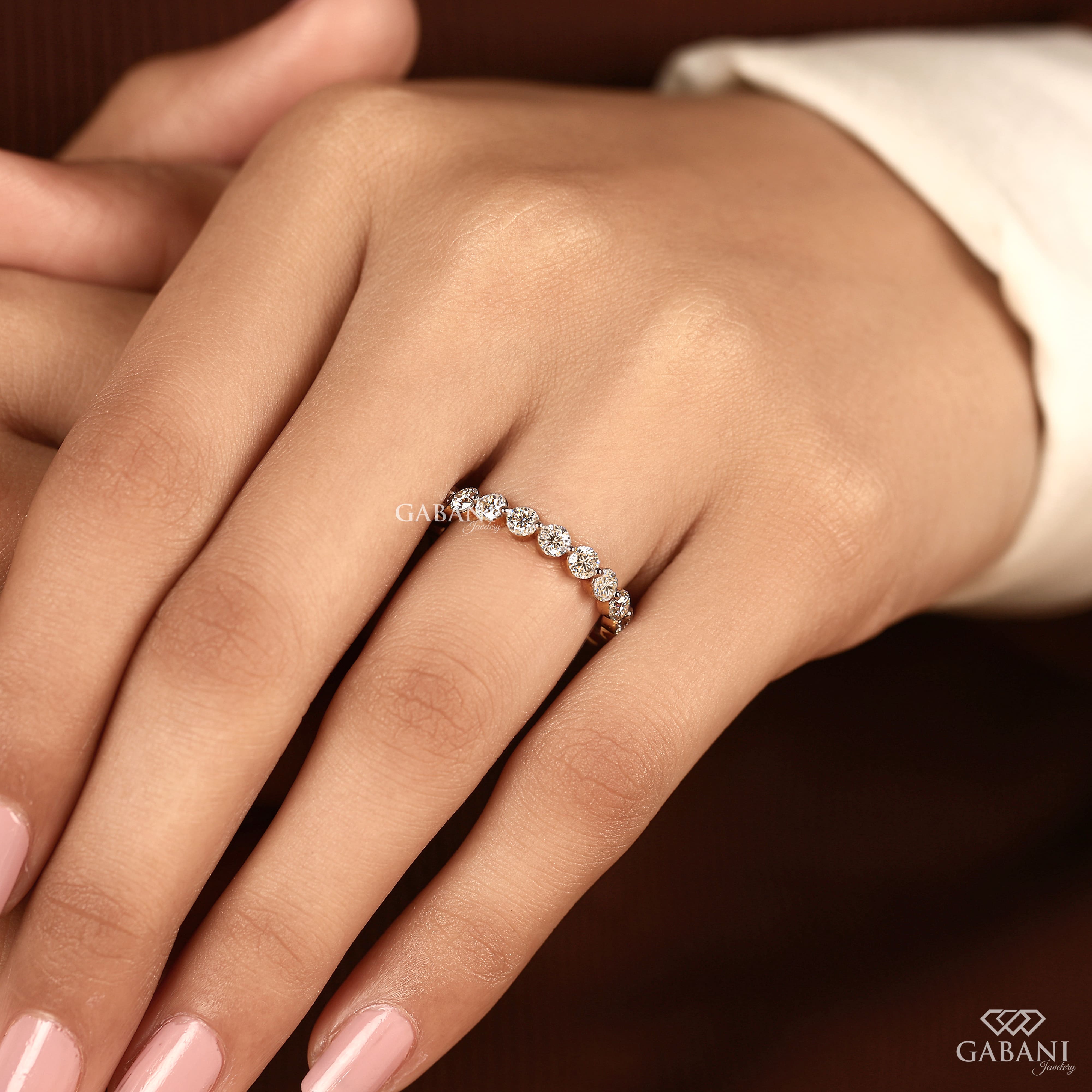 Round cut lab grown diamond full eternity wedding band in yellow gold with shared prong setting.
