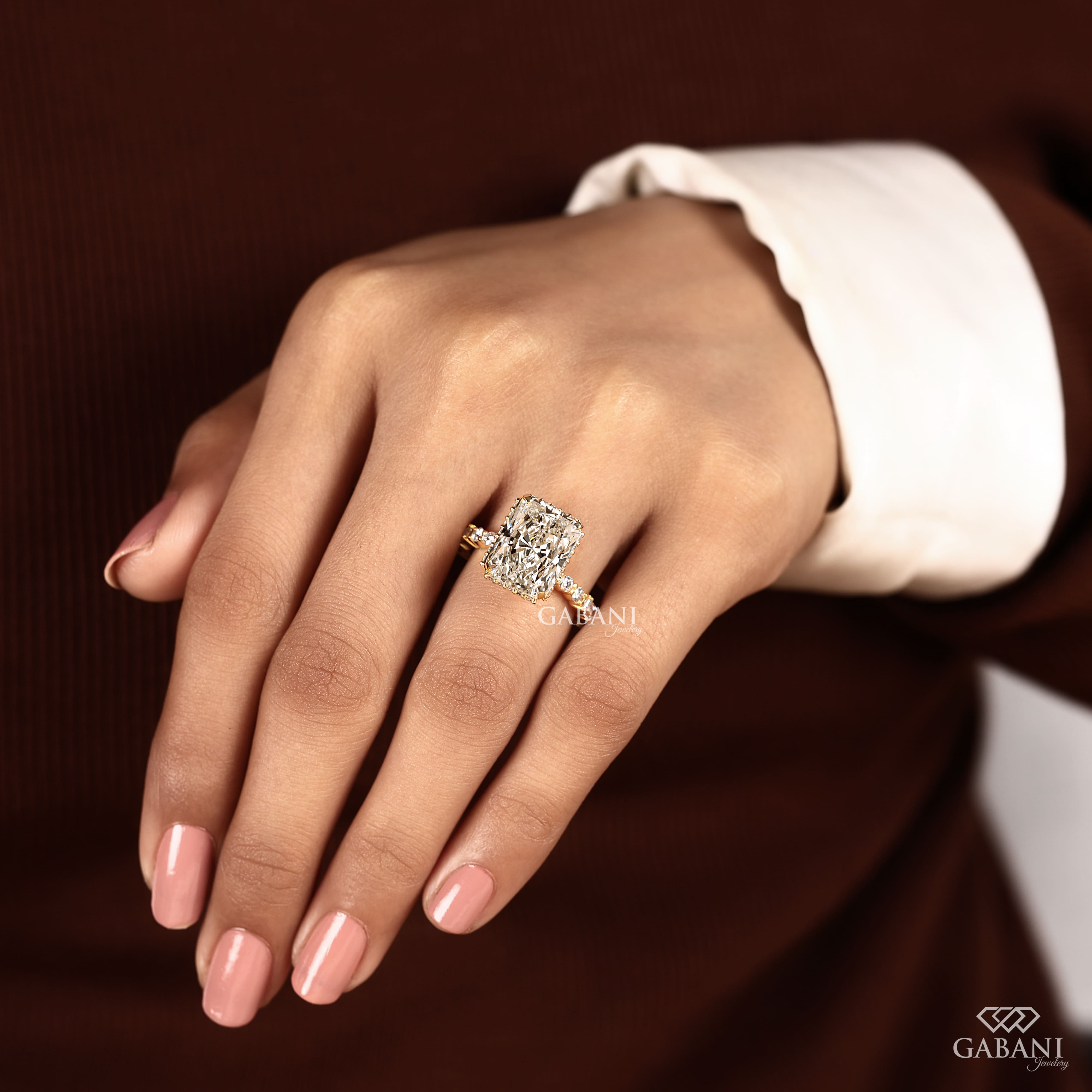 Radiant cut lab grown diamond engagement ring with hidden halo, round and baguette side diamonds, and polished gold band.