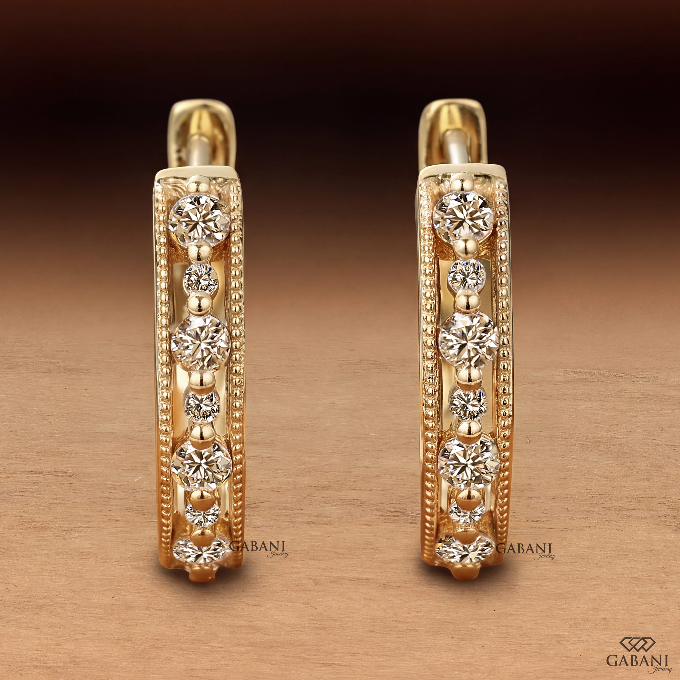 Round cut diamond milgrain hoop earrings in yellow gold with graduated diamonds and beaded edge detailing.
