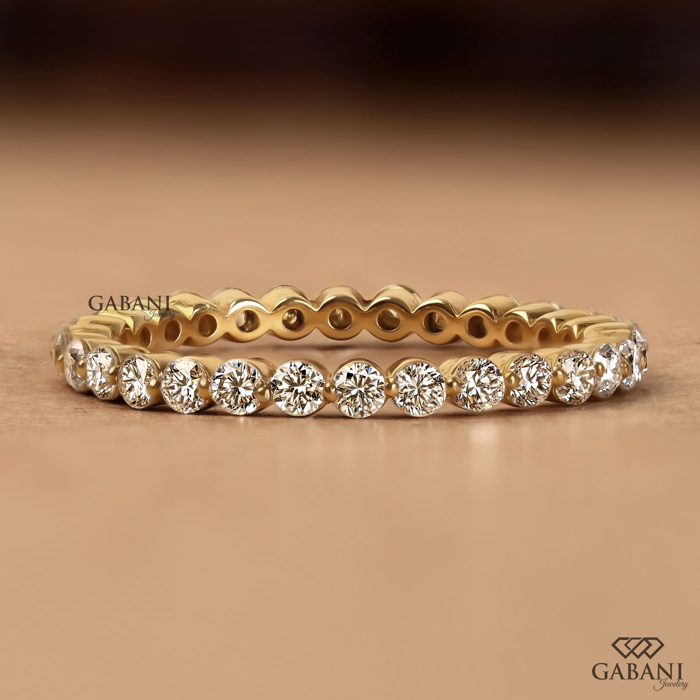 Round cut lab grown diamond bezel set eternity wedding band in solid yellow gold, stackable bridal and anniversary ring.