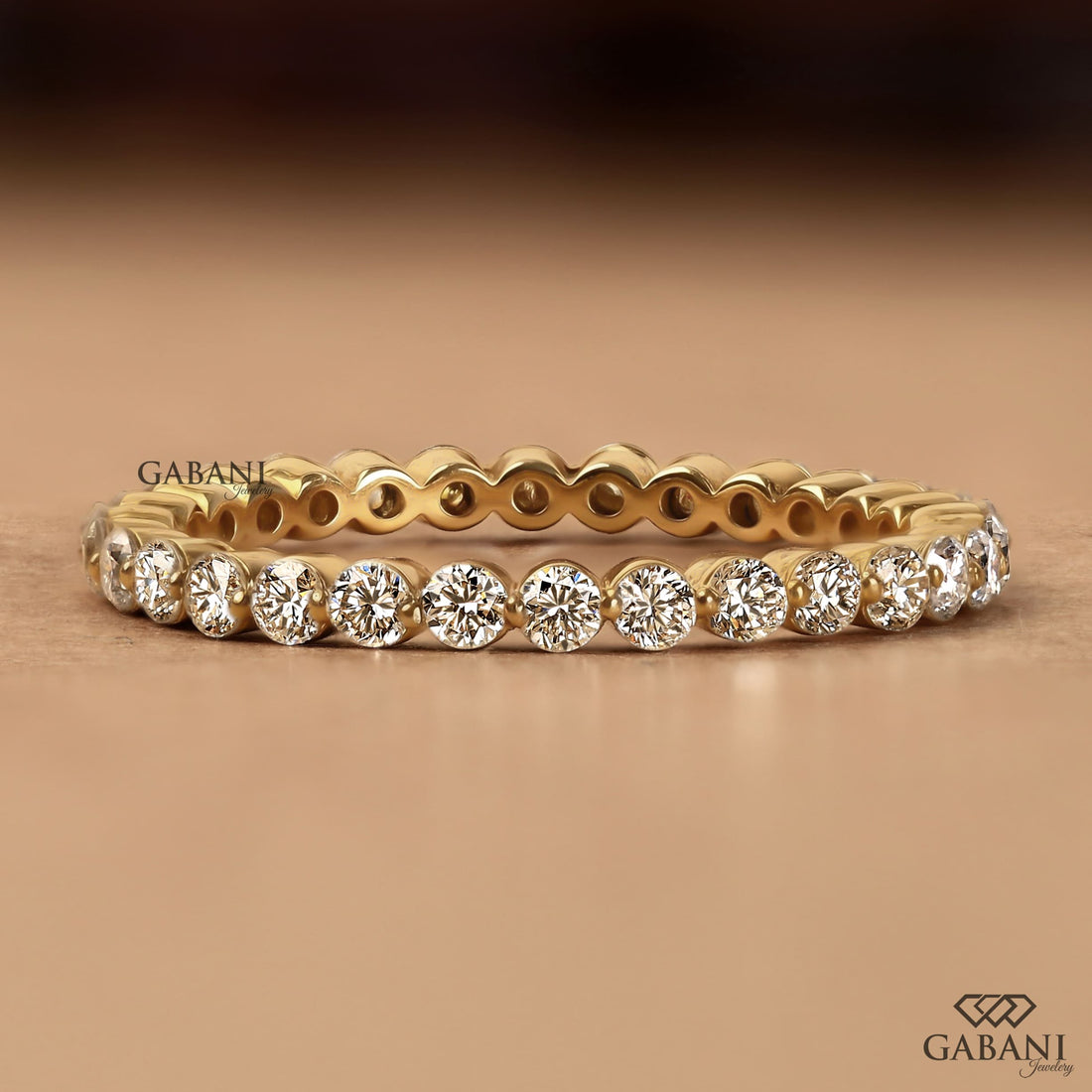 Round cut lab grown diamond bezel set eternity wedding band in solid yellow gold, stackable bridal and anniversary ring.