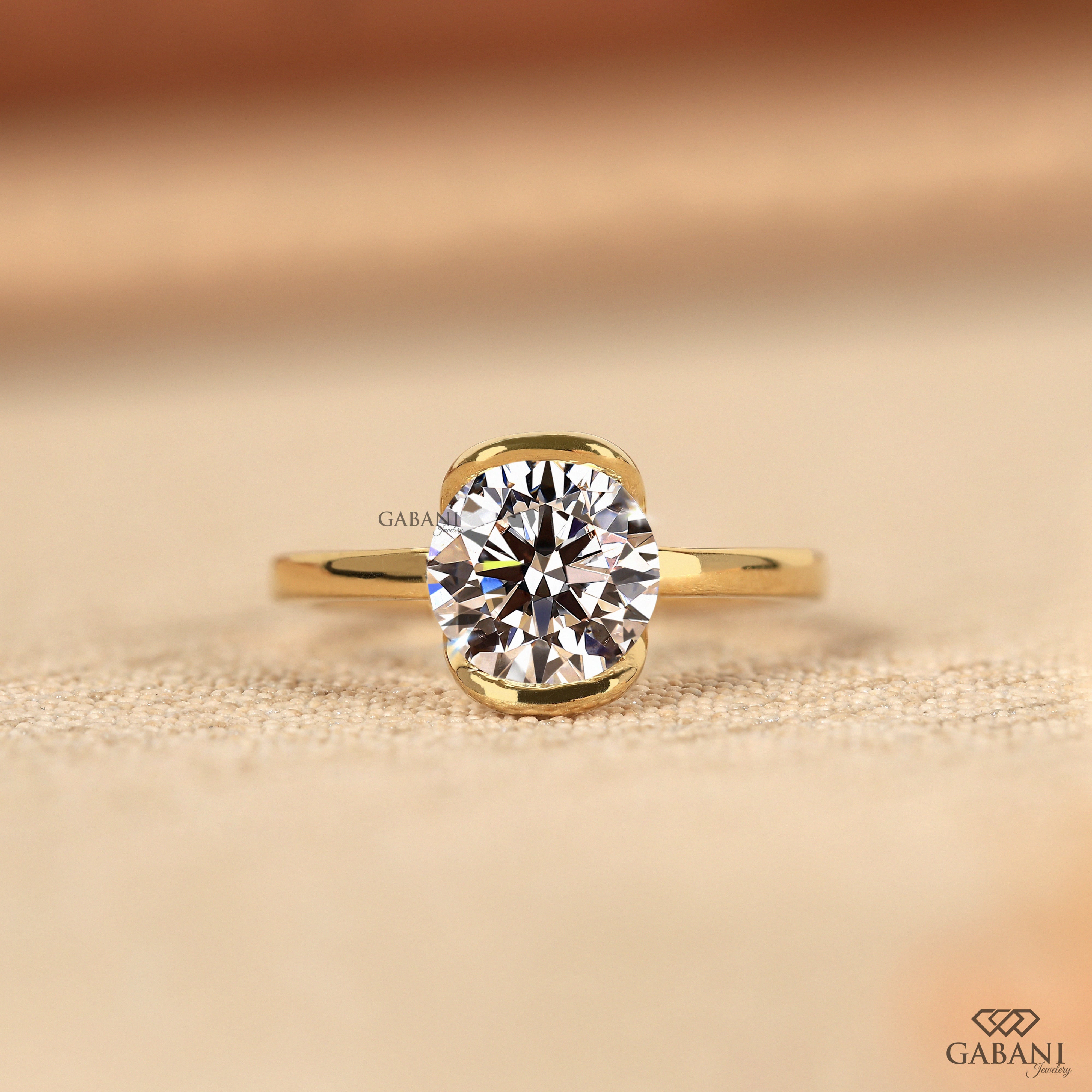 Round diamond half bezel solitaire engagement ring in yellow gold with a slim straight polished band.