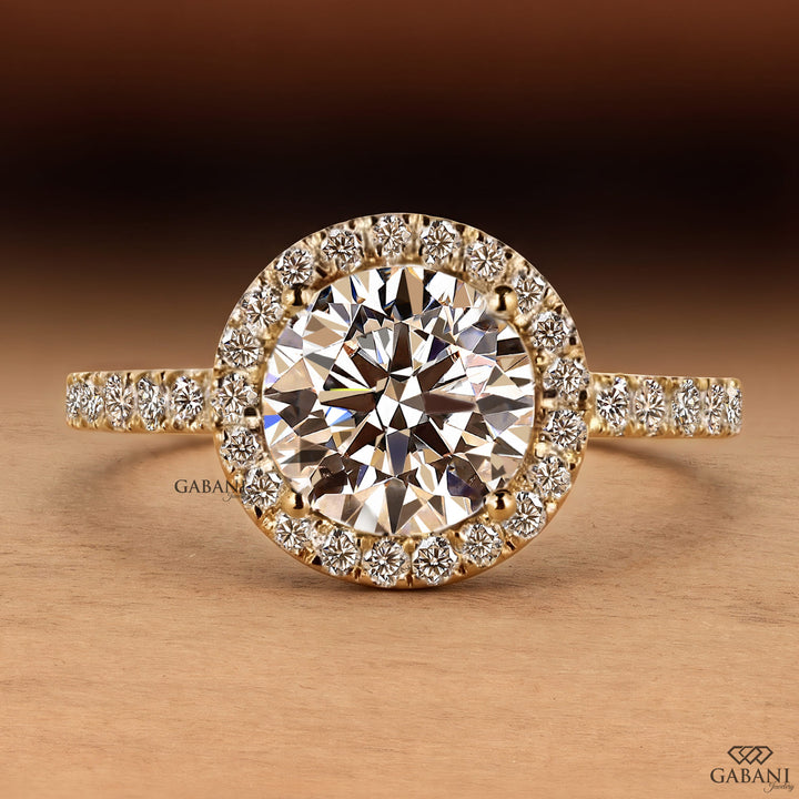 round brilliant cut lab grown diamond engagement ring with a sparkling diamond halo and yellow gold pavé band.