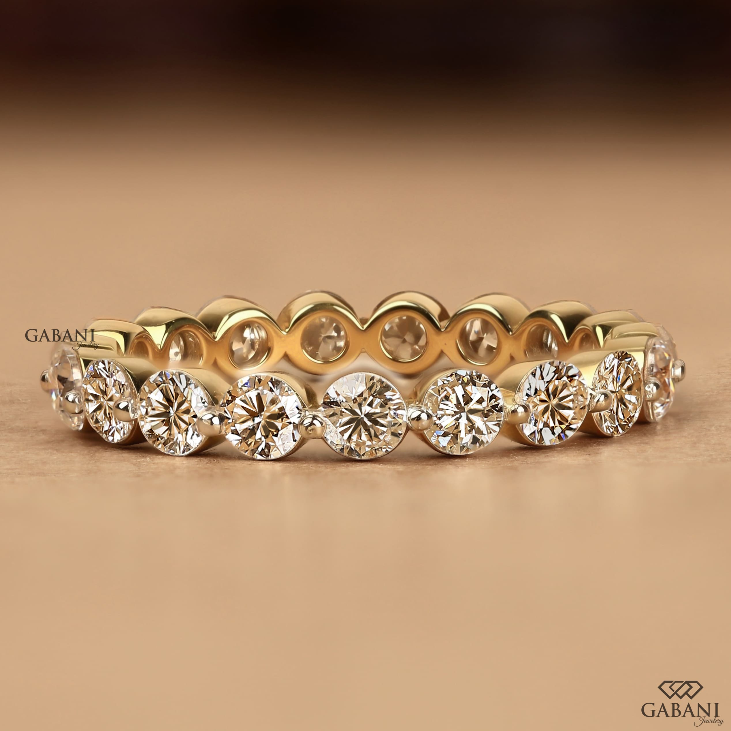 Round cut lab grown diamond full eternity wedding band in yellow gold with shared prong setting.