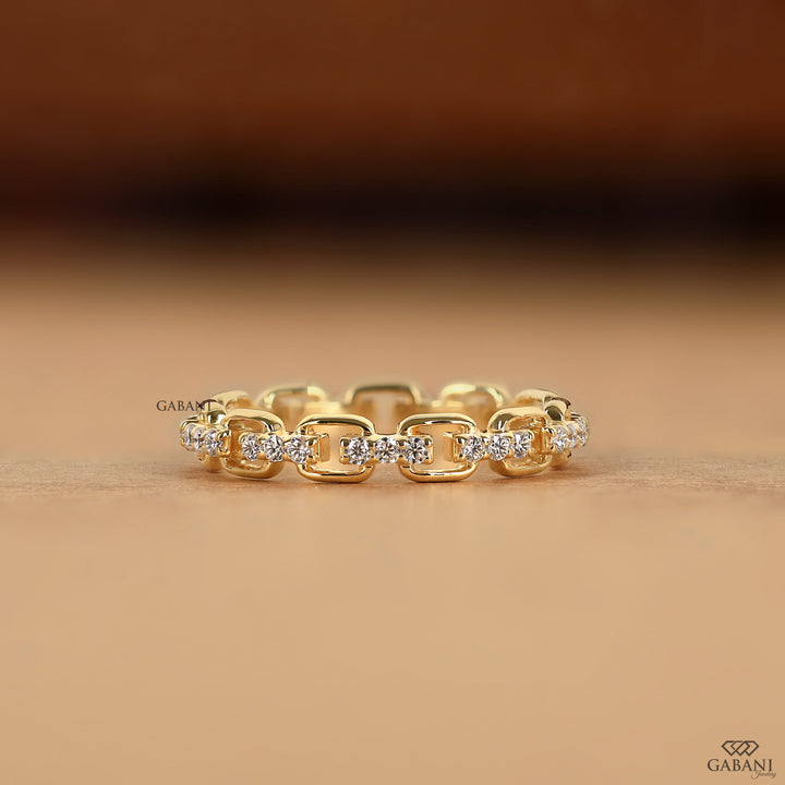 a round lab grown diamond chain link eternity band in 14K yellow gold, featuring prong set diamonds and rectangular gold links.