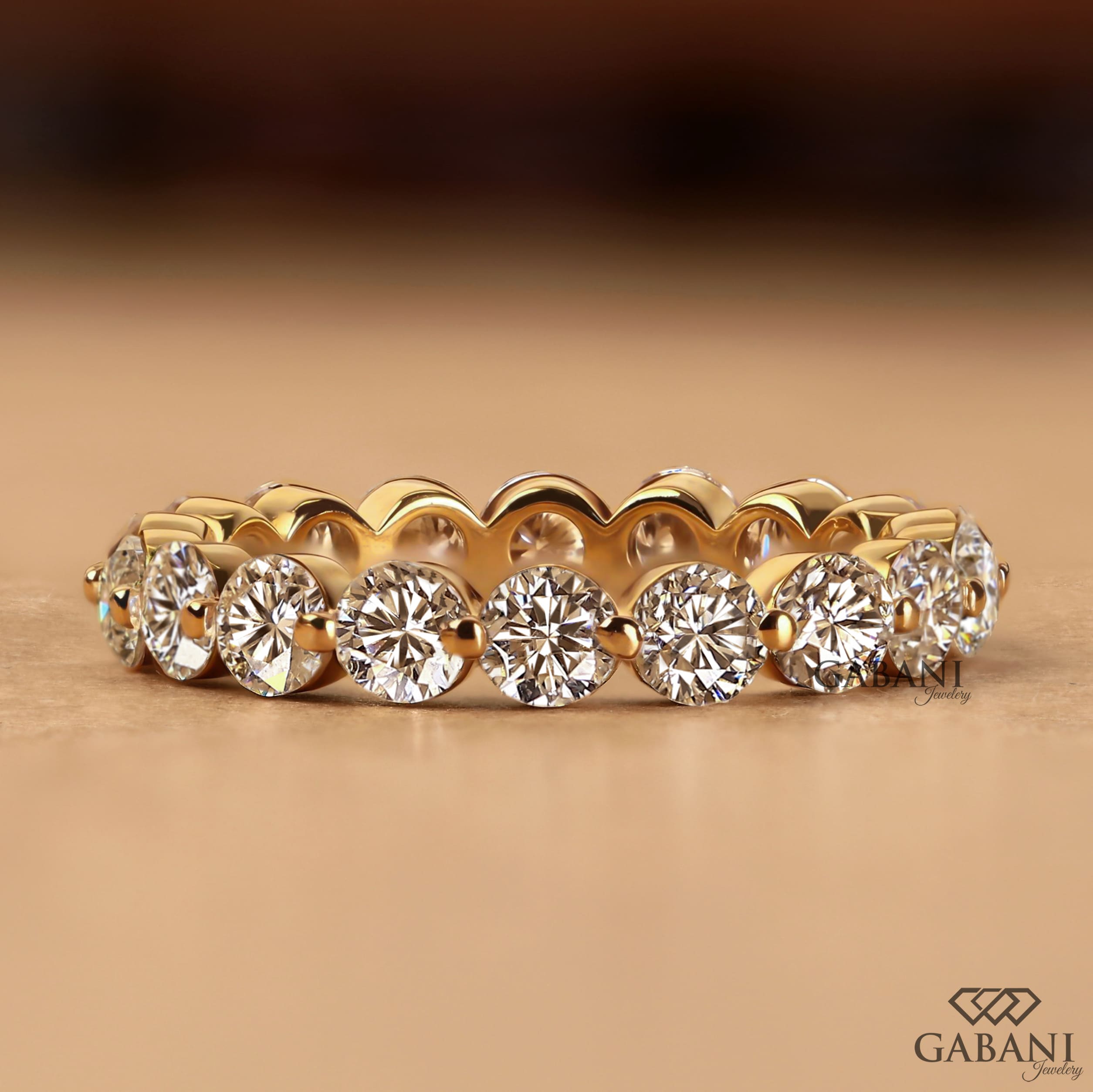 Round cut lab grown diamond full eternity band in yellow gold with shared prong setting