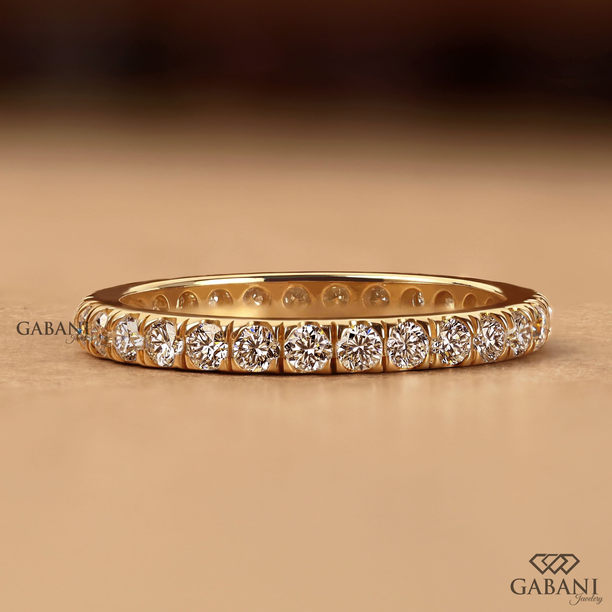 Round cut lab grown diamond eternity wedding band in yellow gold with continuous diamond setting and classic bridal style.