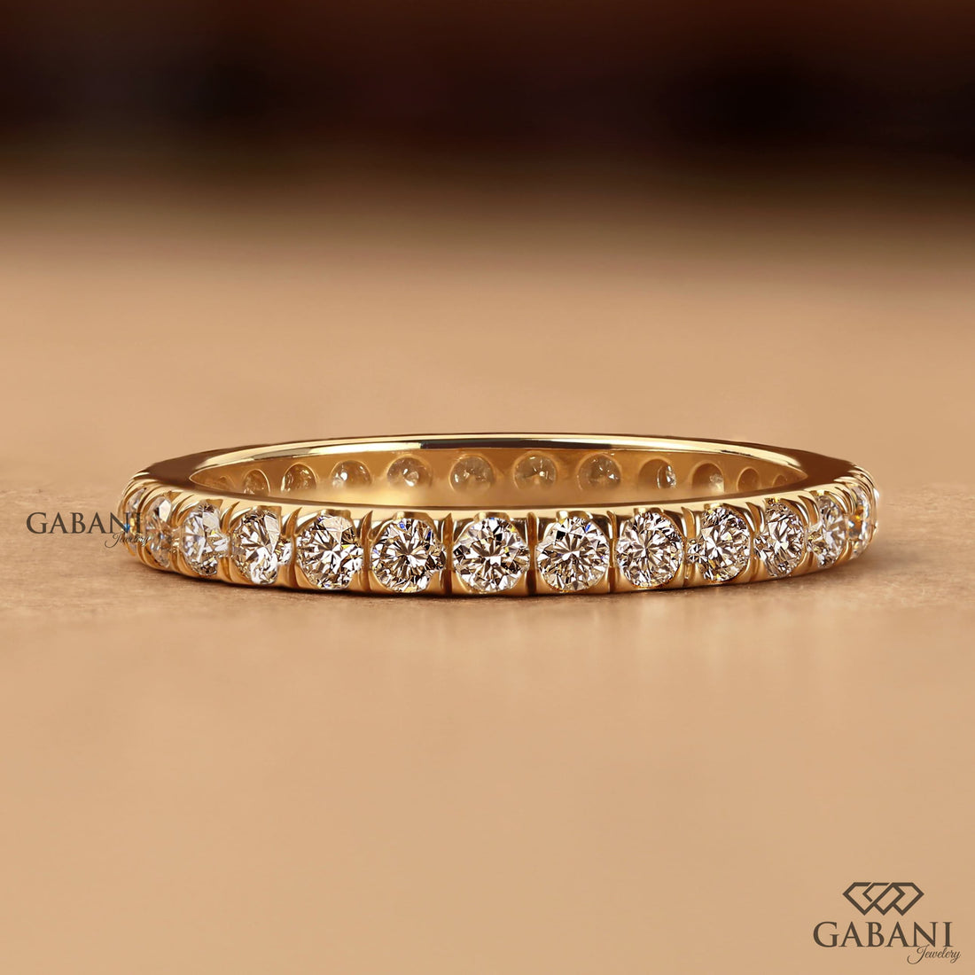 Round cut lab grown diamond eternity wedding band in yellow gold with continuous diamond setting and classic bridal style.