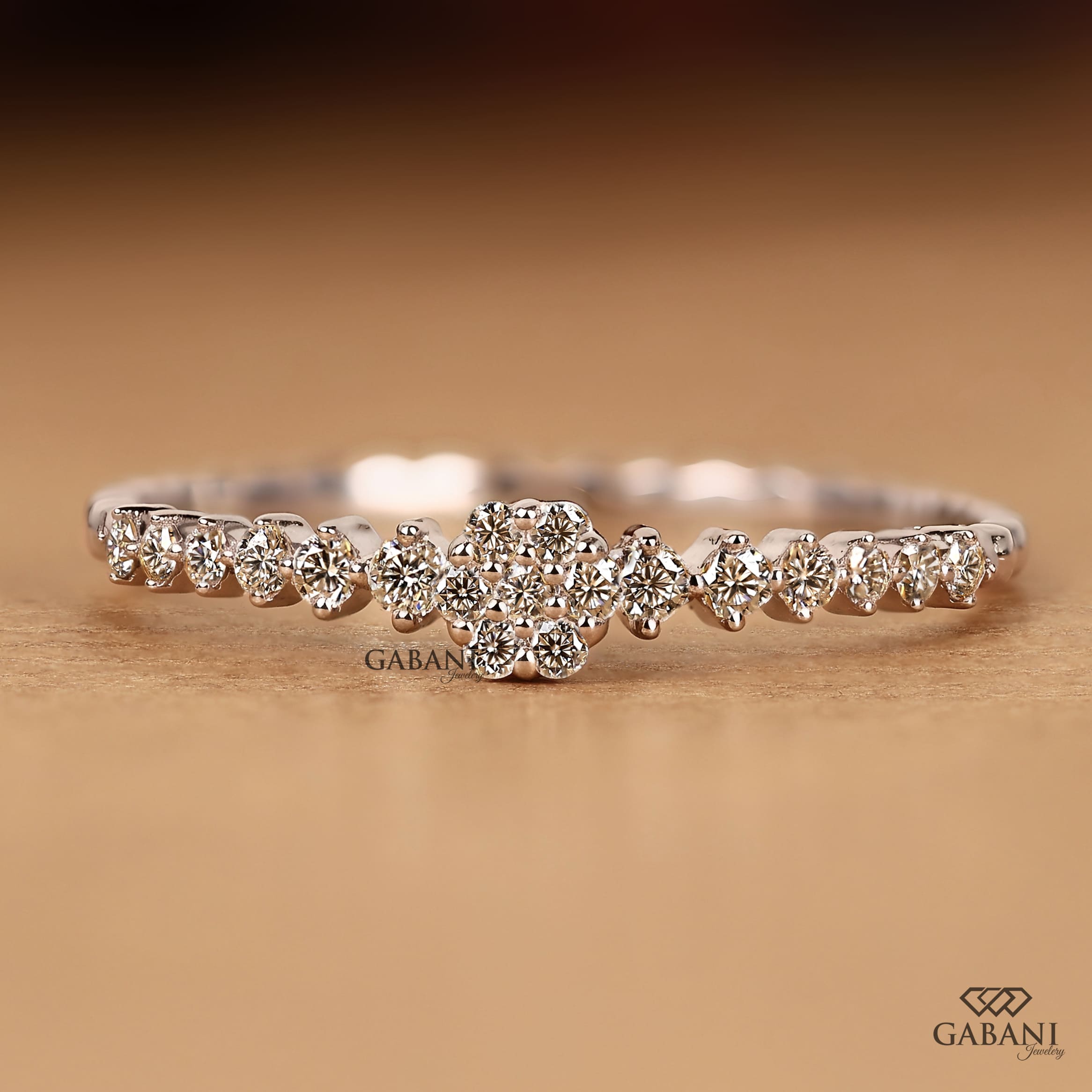 Round lab grown diamond floral cluster wedding band in white gold with graduated side diamonds and prong setting.