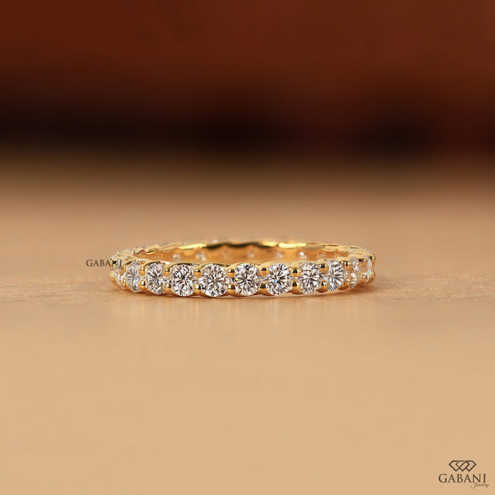 a round lab grown diamond full eternity band in 14K yellow gold, featuring sparkling shared prong set diamonds in a classic wedding band design by Gabani Jewelry.