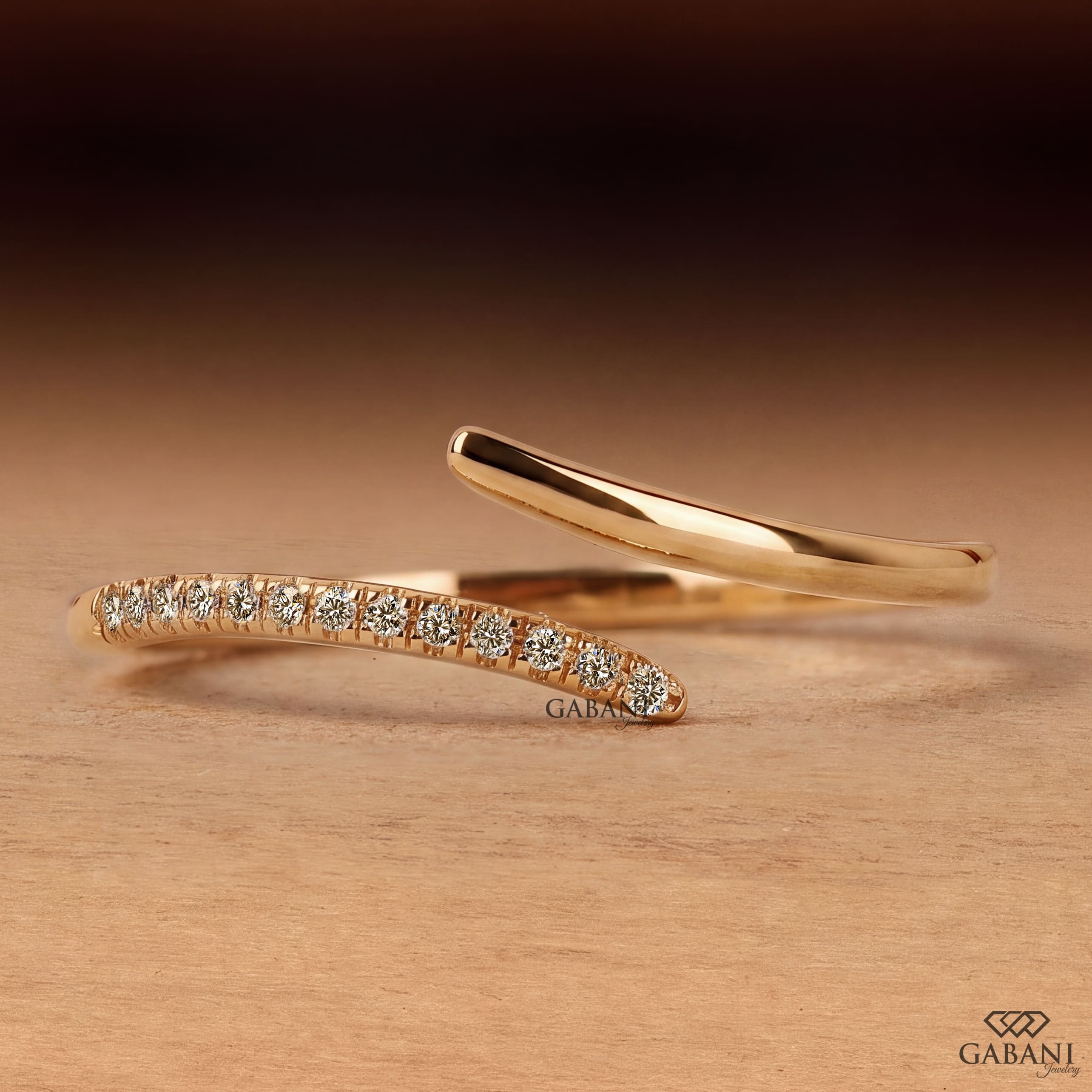 a round lab grown diamond open cuff bangle bracelet in 14K yellow gold, featuring sparkling round diamonds along one curved end and a smooth polished gold wrap design by Gabani Jewelry.