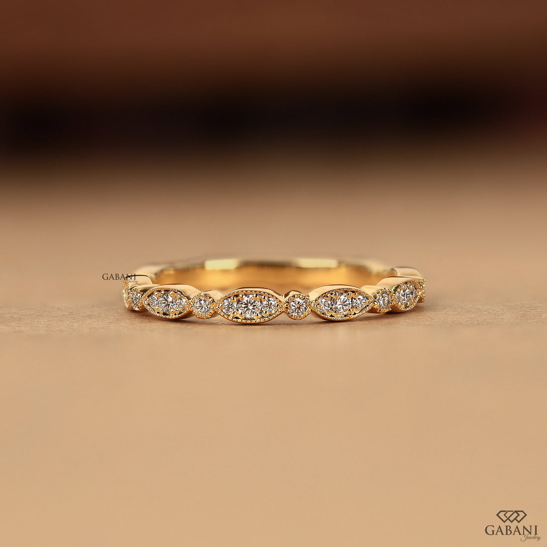 a round cut lab grown diamond wedding band in 14K yellow gold, featuring marquise-inspired diamond clusters, delicate milgrain detailing and a vintage design by Gabani Jewelry.