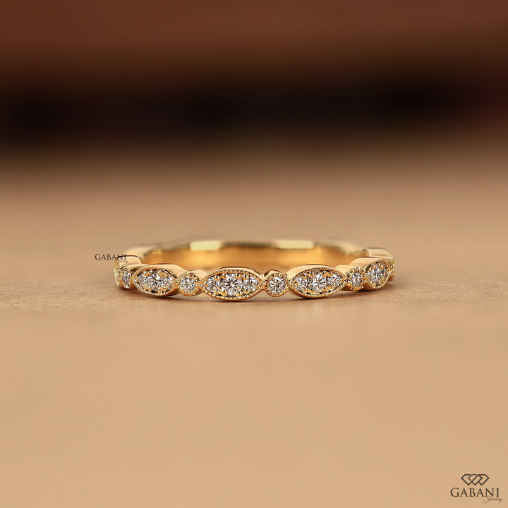 a round cut lab grown diamond wedding band in 14K yellow gold, featuring marquise-inspired diamond clusters, delicate milgrain detailing and a vintage design by Gabani Jewelry.