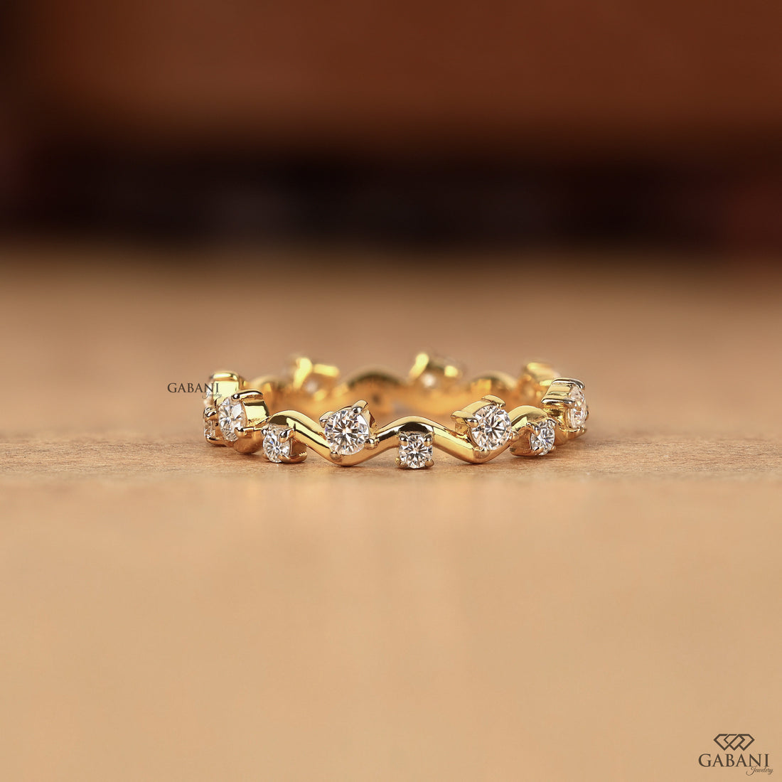 a round lab grown diamond zigzag eternity band in 14K yellow gold, featuring alternating round diamonds in a unique wave design.
