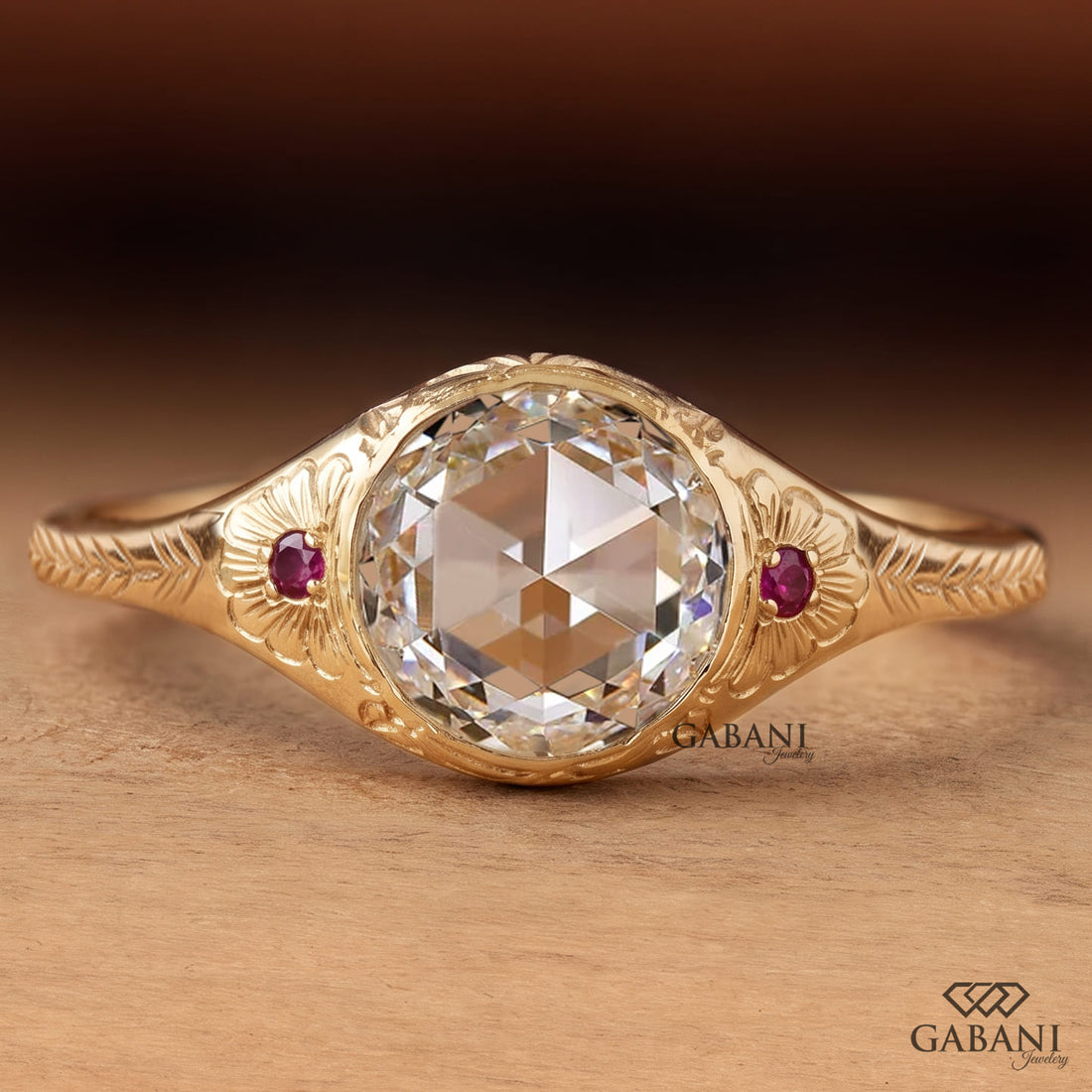 Round rose cut lab grown diamond engagement ring with ruby side accents, floral engraving, and bezel setting