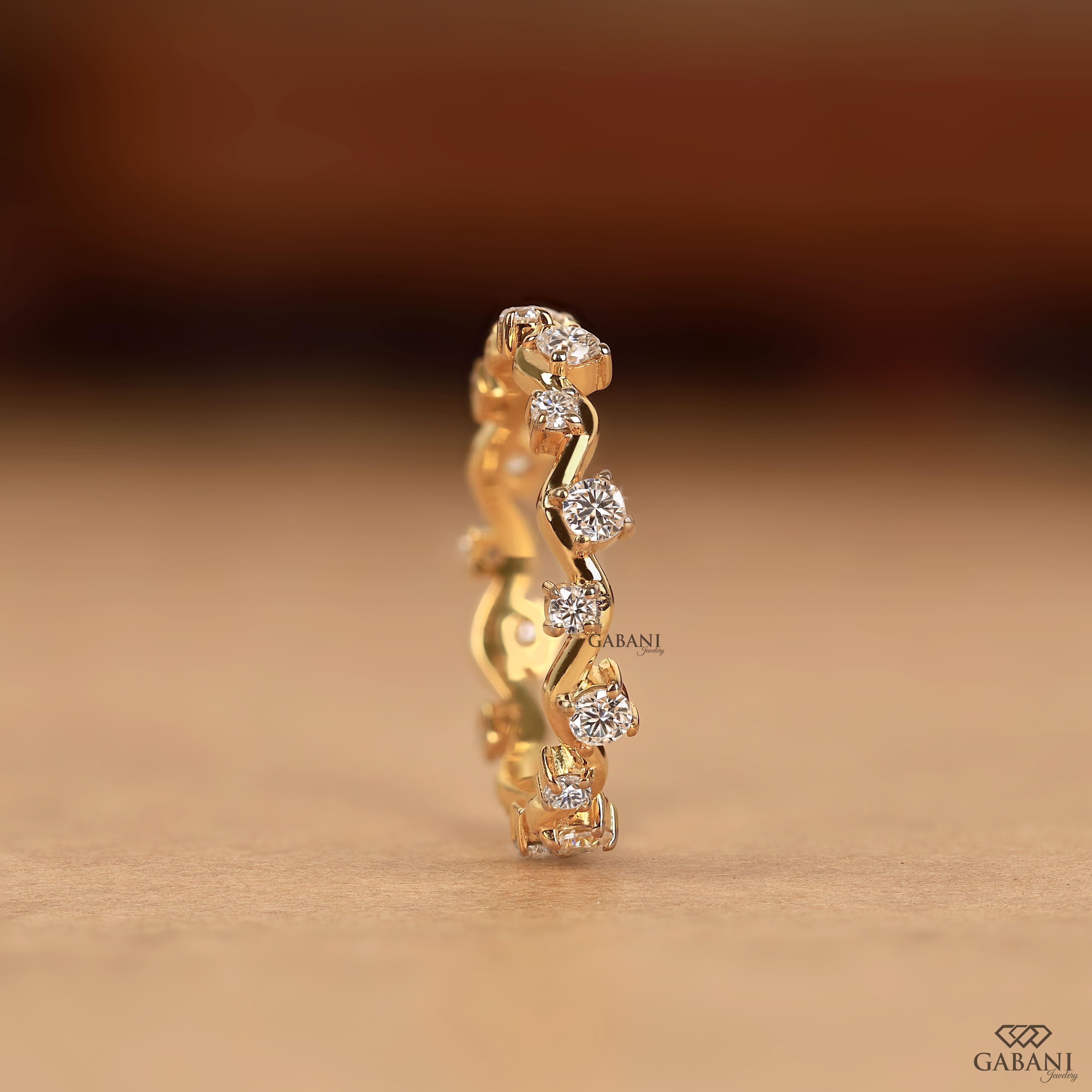 a round lab grown diamond zigzag eternity band in 14K yellow gold, featuring alternating round diamonds in a unique wave design.
