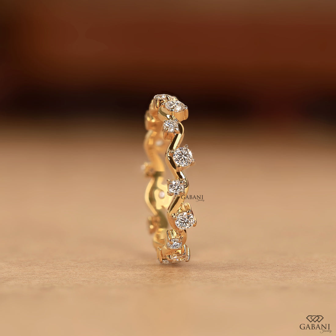 a round lab grown diamond zigzag eternity band in 14K yellow gold, featuring alternating round diamonds in a unique wave design.