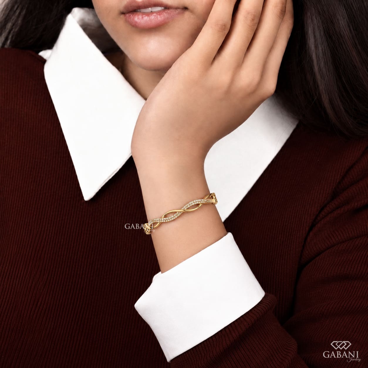 Yellow gold infinity twist bangle bracelet with intertwined polished bands and double rows of round pavé set diamonds.