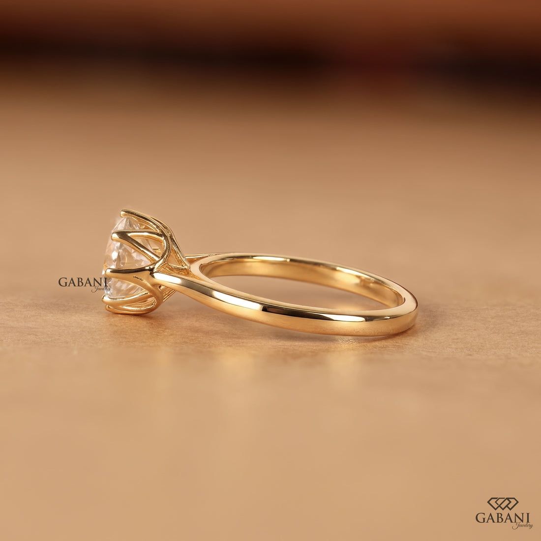 Shop a round Portuguese cut lab grown diamond solitaire engagement ring with a six-prong floral basket and polished yellow gold band.