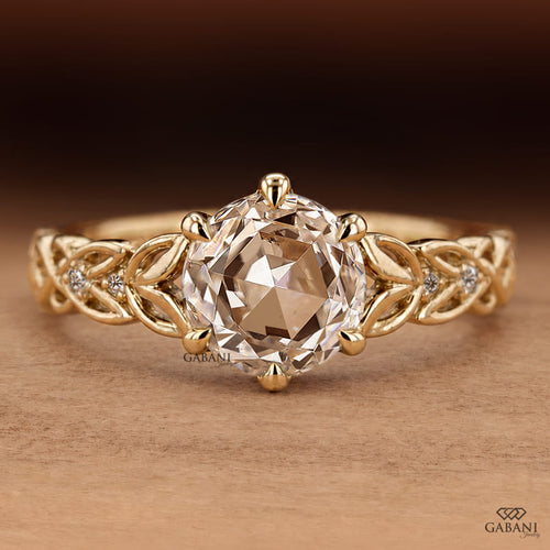 Oval rose cut lab grown diamond engagement ring with leaf vine band, round diamond accents, and six claw prong setting in 14K yellow gold.