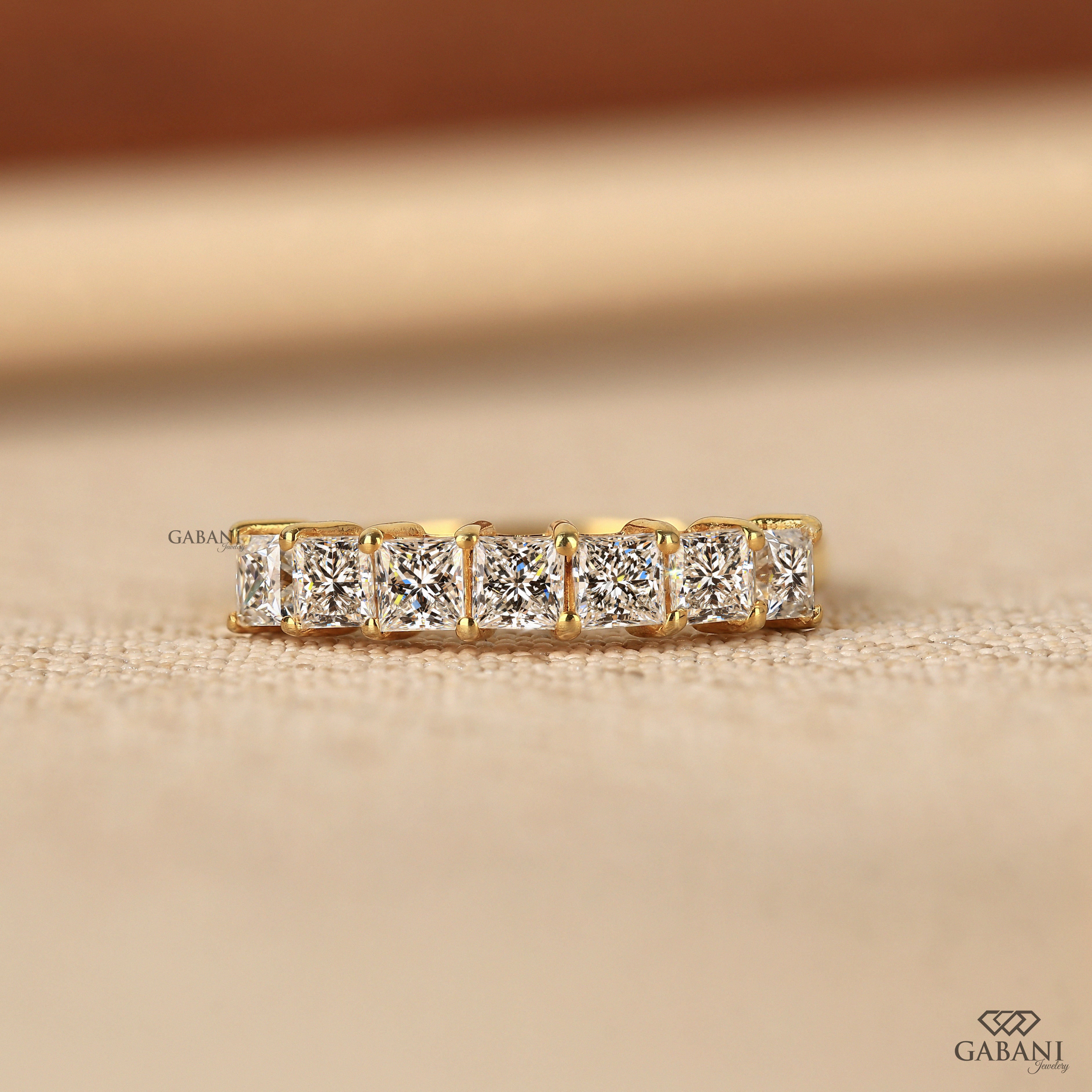 seven stone princess cut lab grown diamond wedding band in 14K yellow gold. A classic half eternity ring for weddings, anniversaries and stacking.