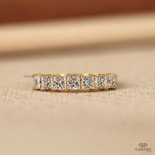 seven stone princess cut lab grown diamond wedding band in 14K yellow gold. A classic half eternity ring for weddings, anniversaries and stacking.