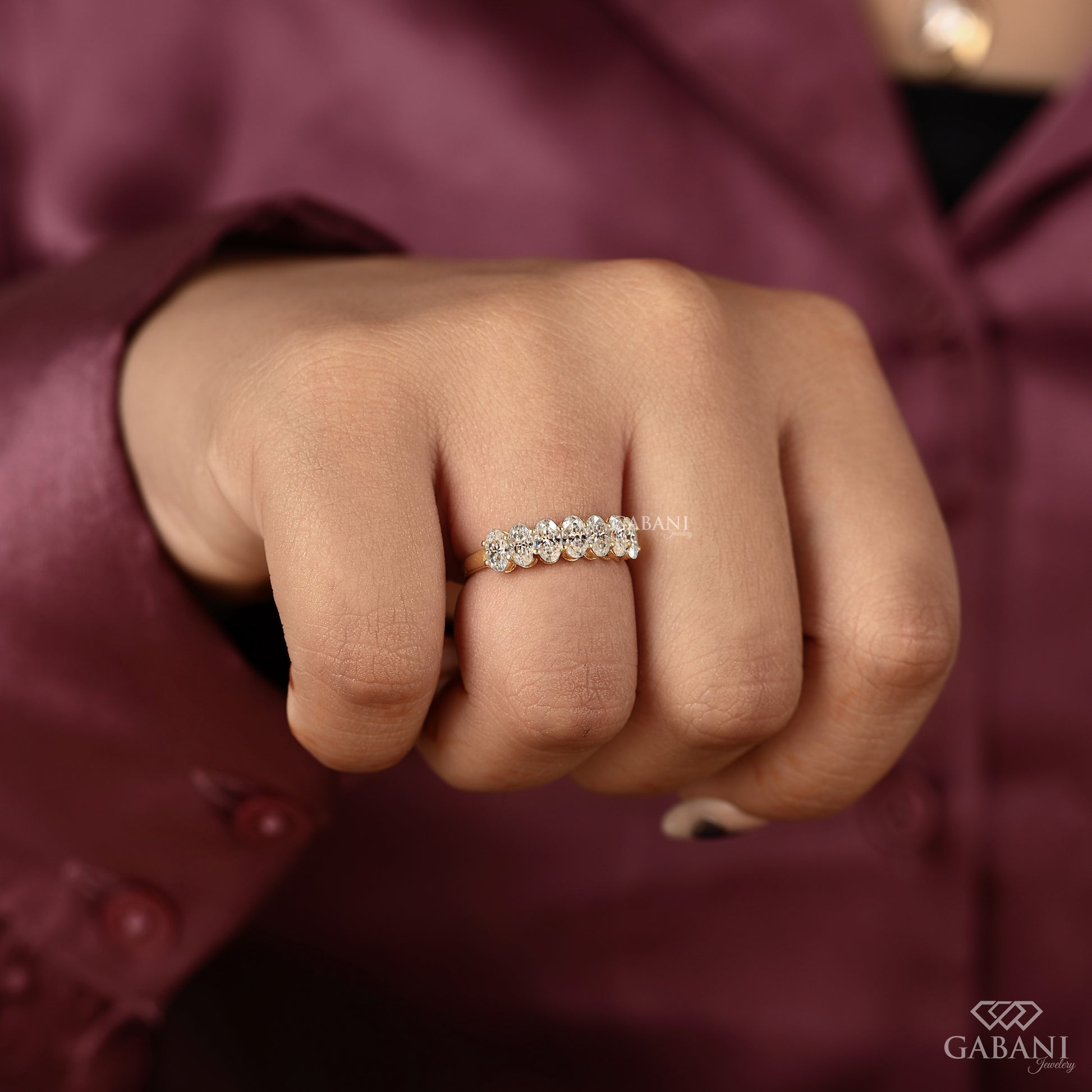 oval lab grown diamond band in yellow gold featuring seven stone wedding style