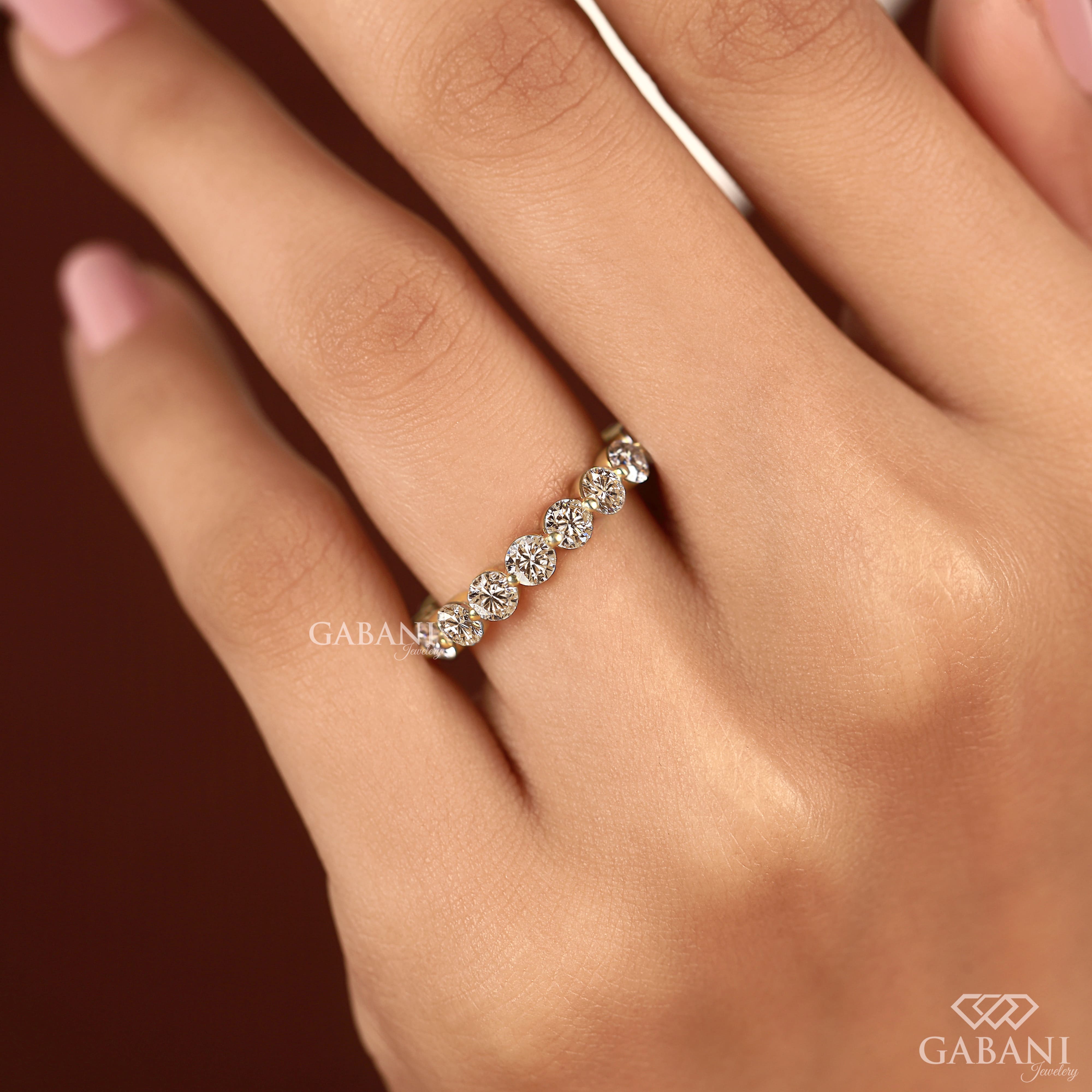 Round lab grown diamond shared prong full eternity wedding band in yellow gold with continuous diamond setting.
