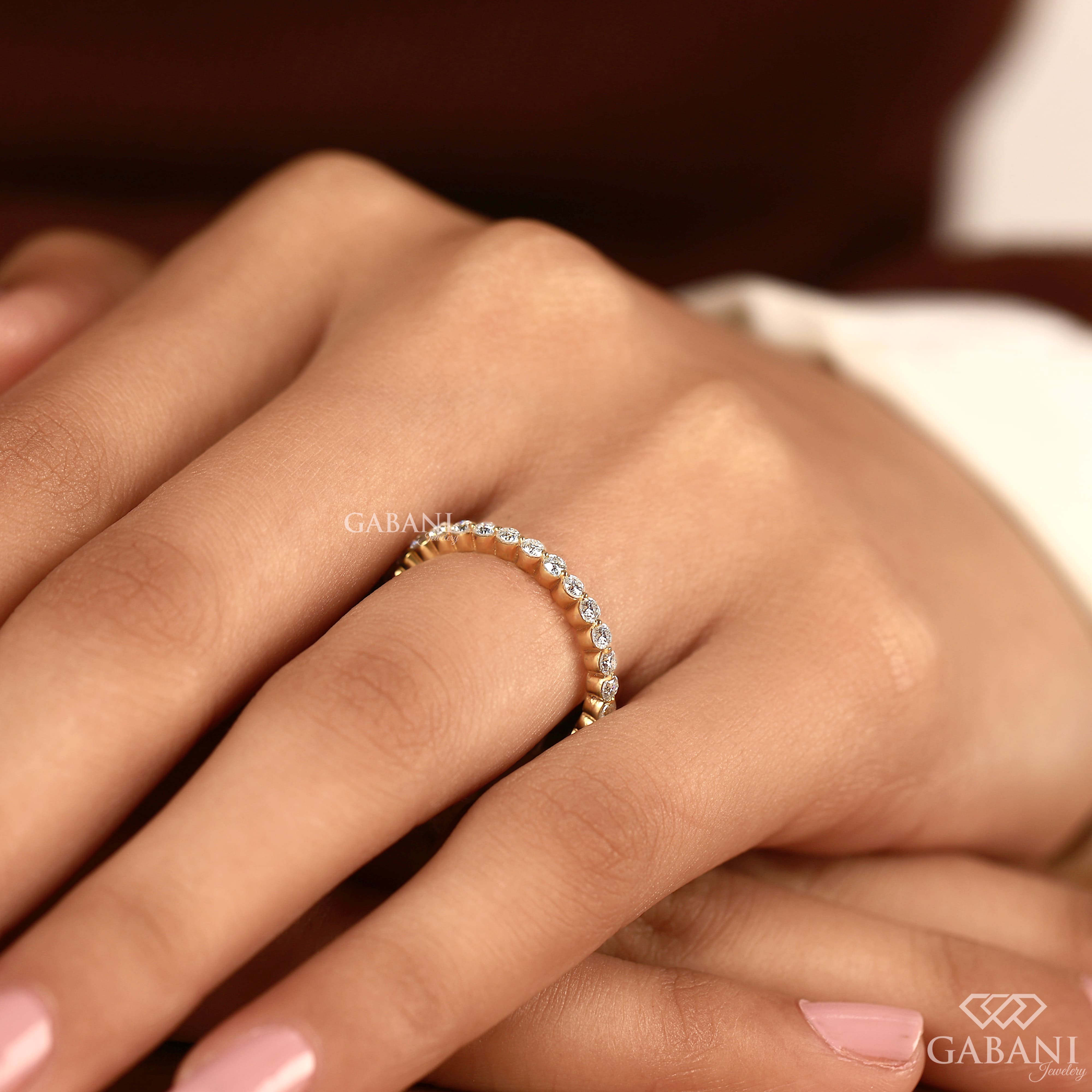 Round cut lab grown diamond full eternity wedding band in yellow gold with shared prong setting and continuous diamond design.