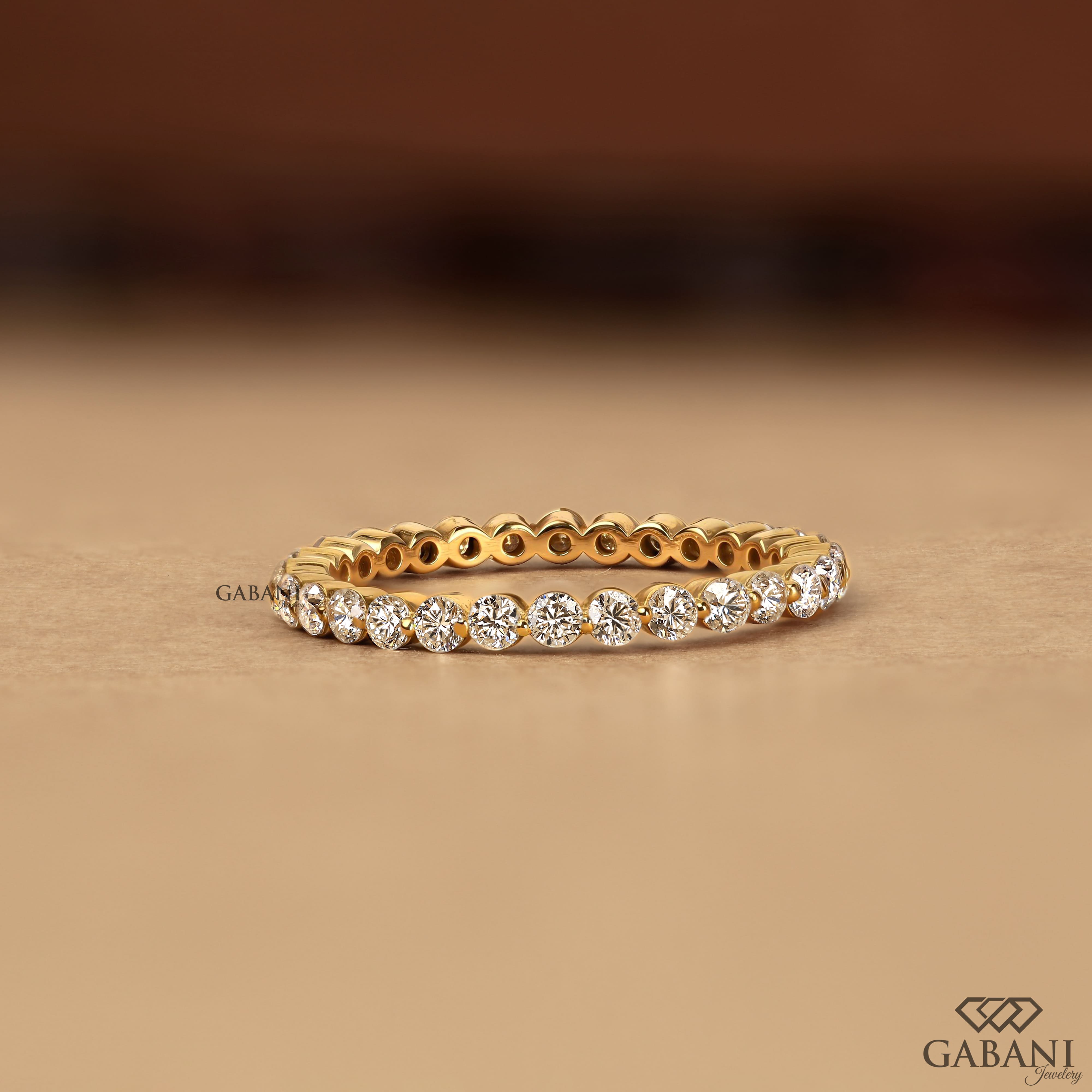 Round cut lab grown diamond full eternity wedding band in yellow gold with shared prong setting and continuous diamond design.