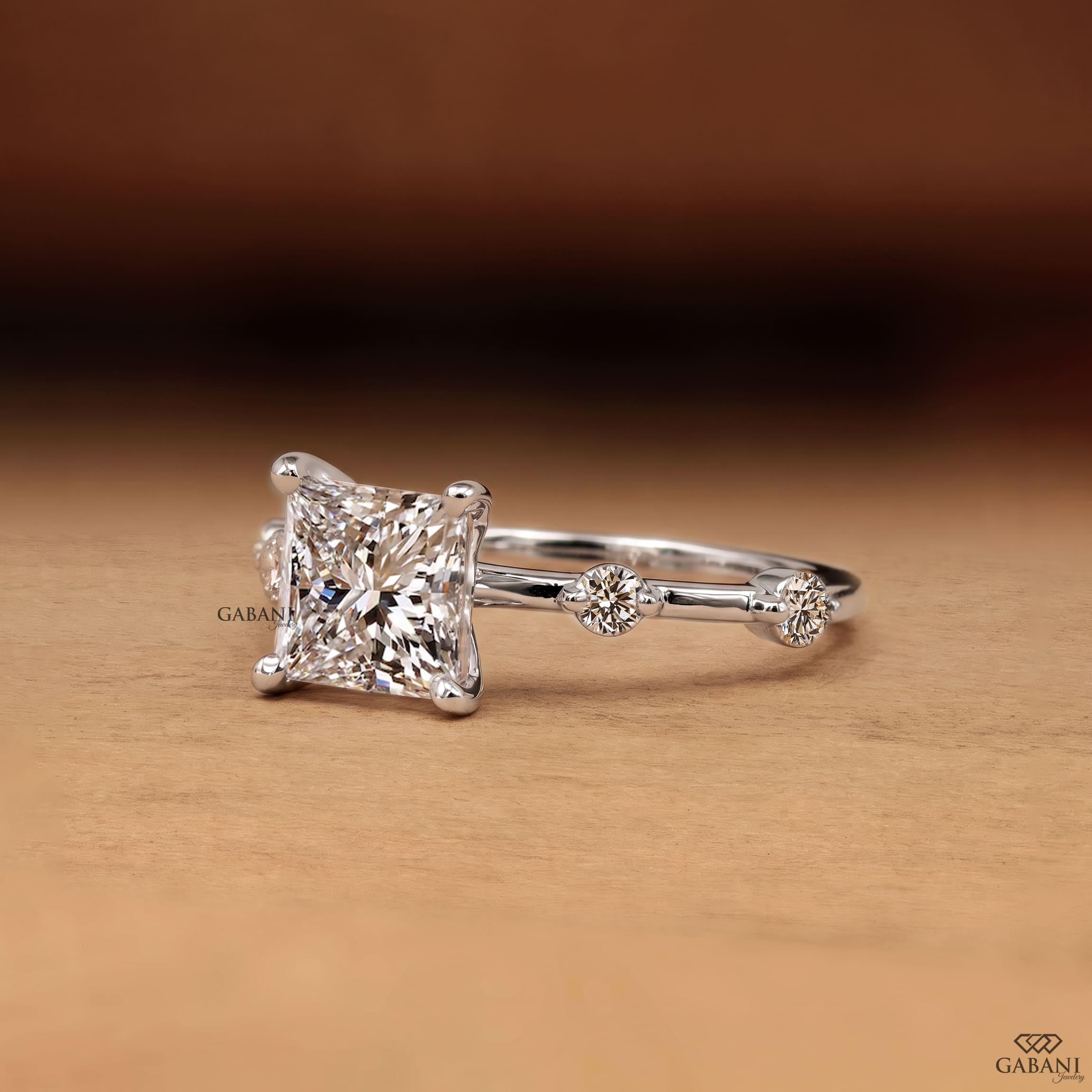 Princess cut lab grown diamond engagement ring in white gold with a four prong center setting and spaced round diamond side stones along the polished band.