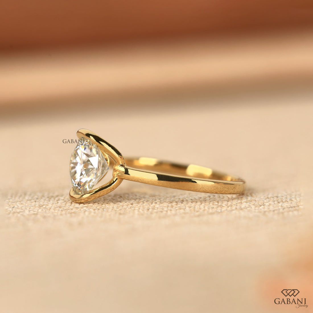 Round diamond half bezel solitaire engagement ring in yellow gold with a slim straight polished band.