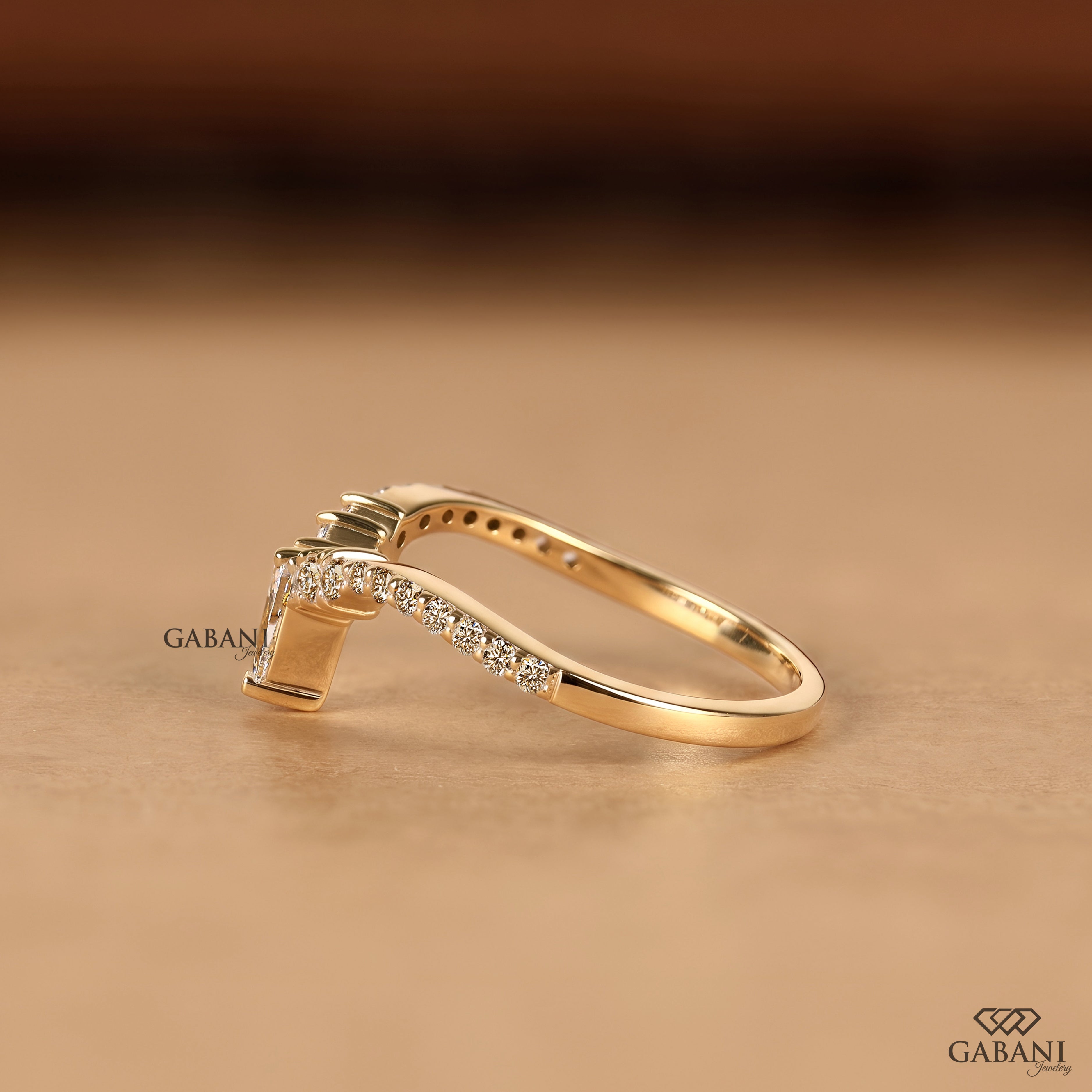 Side view of pear cut lab grown diamond V shaped chevron wedding band in solid gold