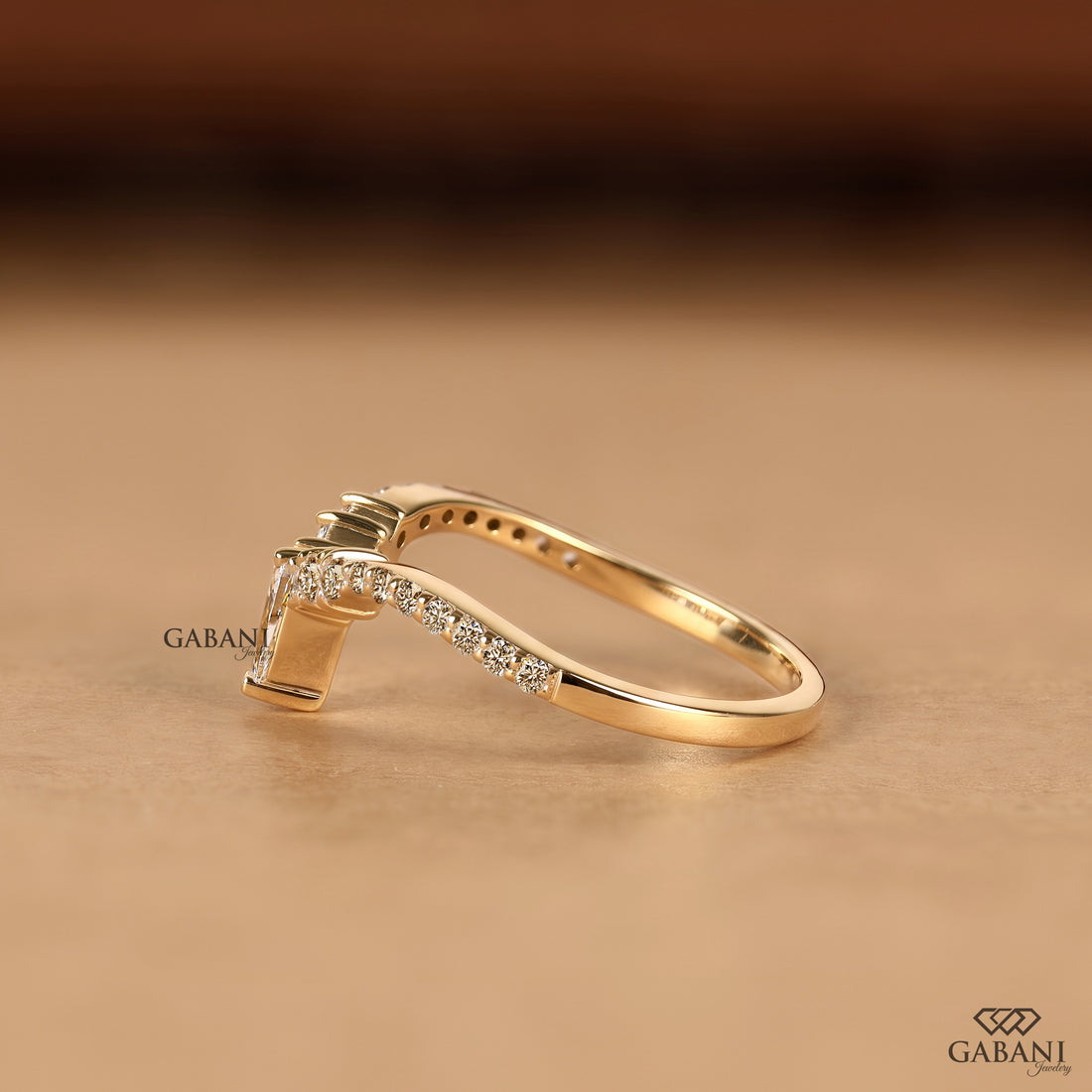 Side view of pear cut lab grown diamond V shaped chevron wedding band in solid gold