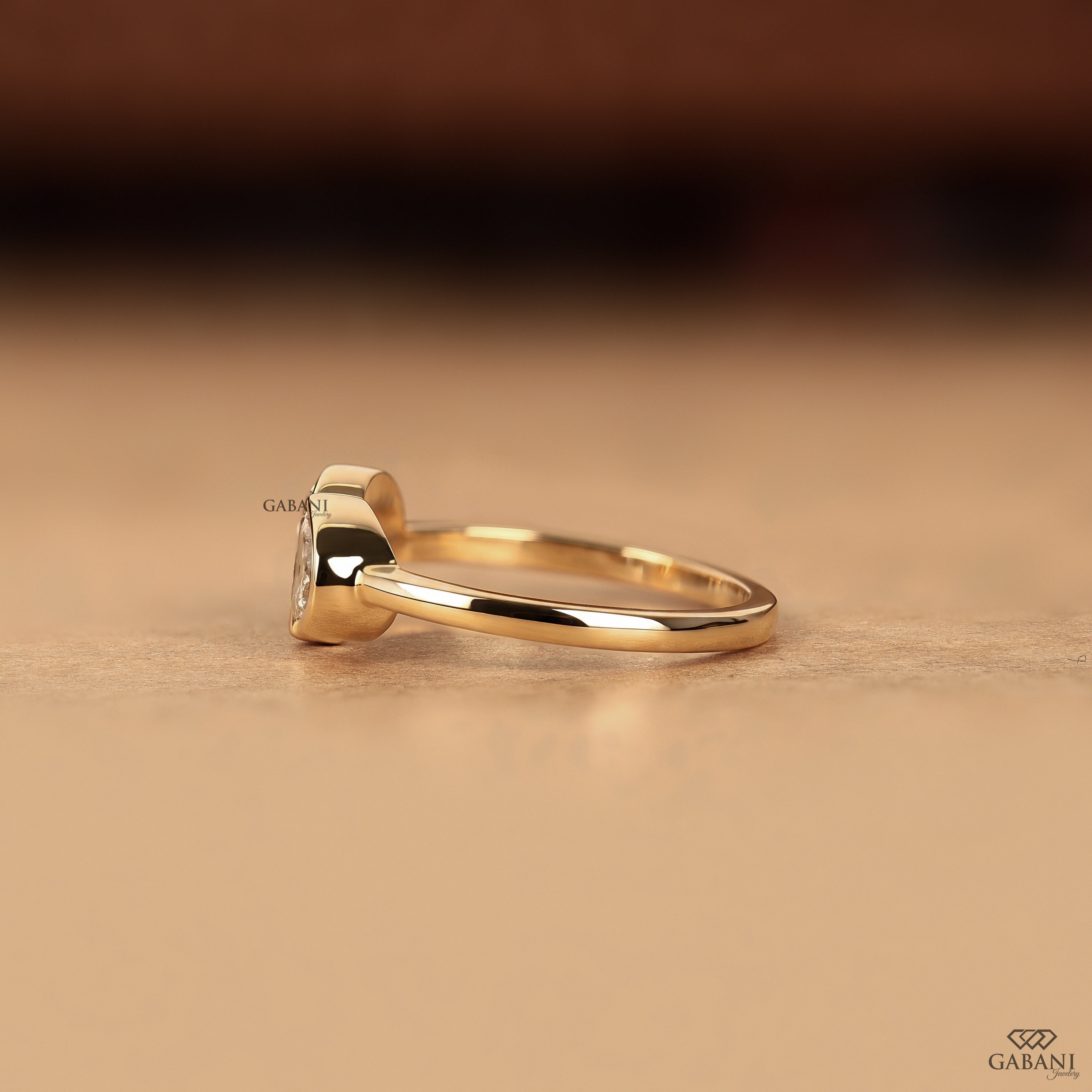 Side view of a pear cut lab grown diamond Toi et Moi ring with secure bezel settings and a low profile design