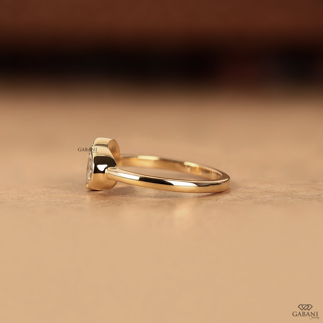 Side view of a pear cut lab grown diamond Toi et Moi ring with secure bezel settings and a low profile design