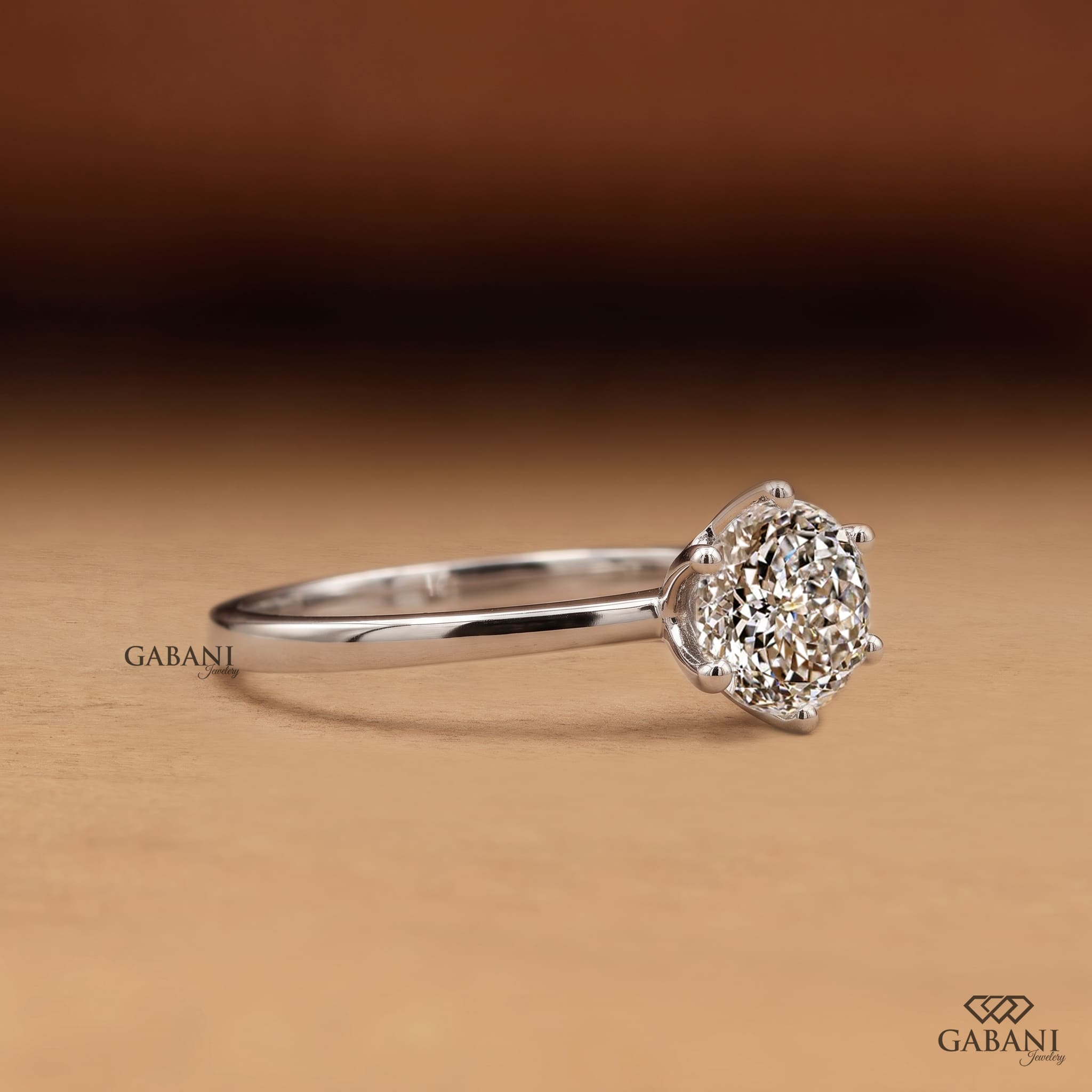 Round Portuguese cut lab grown diamond solitaire engagement ring in white gold with a six-prong floral basket and polished band.