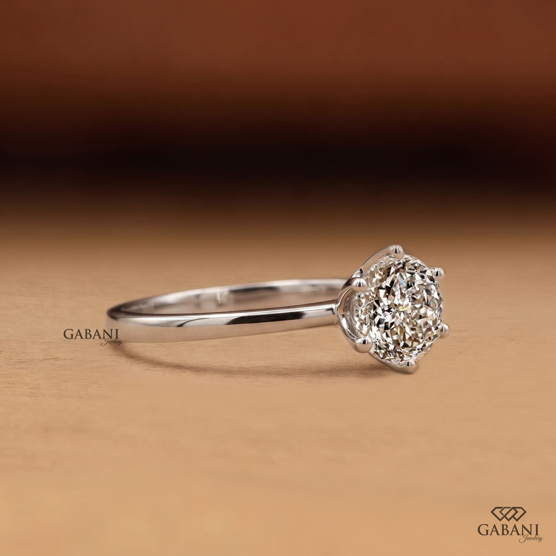 Round Portuguese cut lab grown diamond solitaire engagement ring in white gold with a six-prong floral basket and polished band.