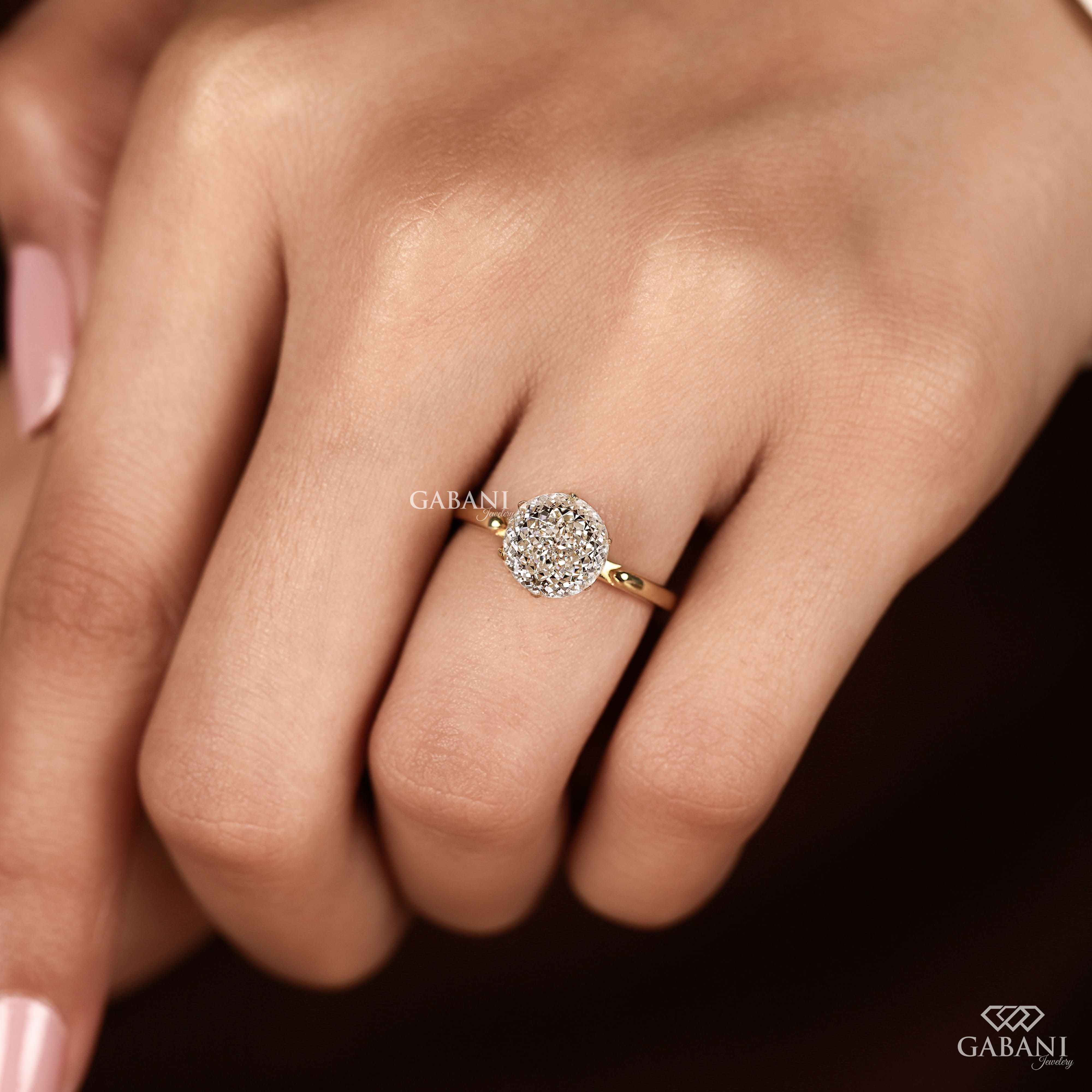 Round Portuguese cut lab grown diamond solitaire engagement ring in yellow gold with a six-prong tulip basket and polished plain band.
