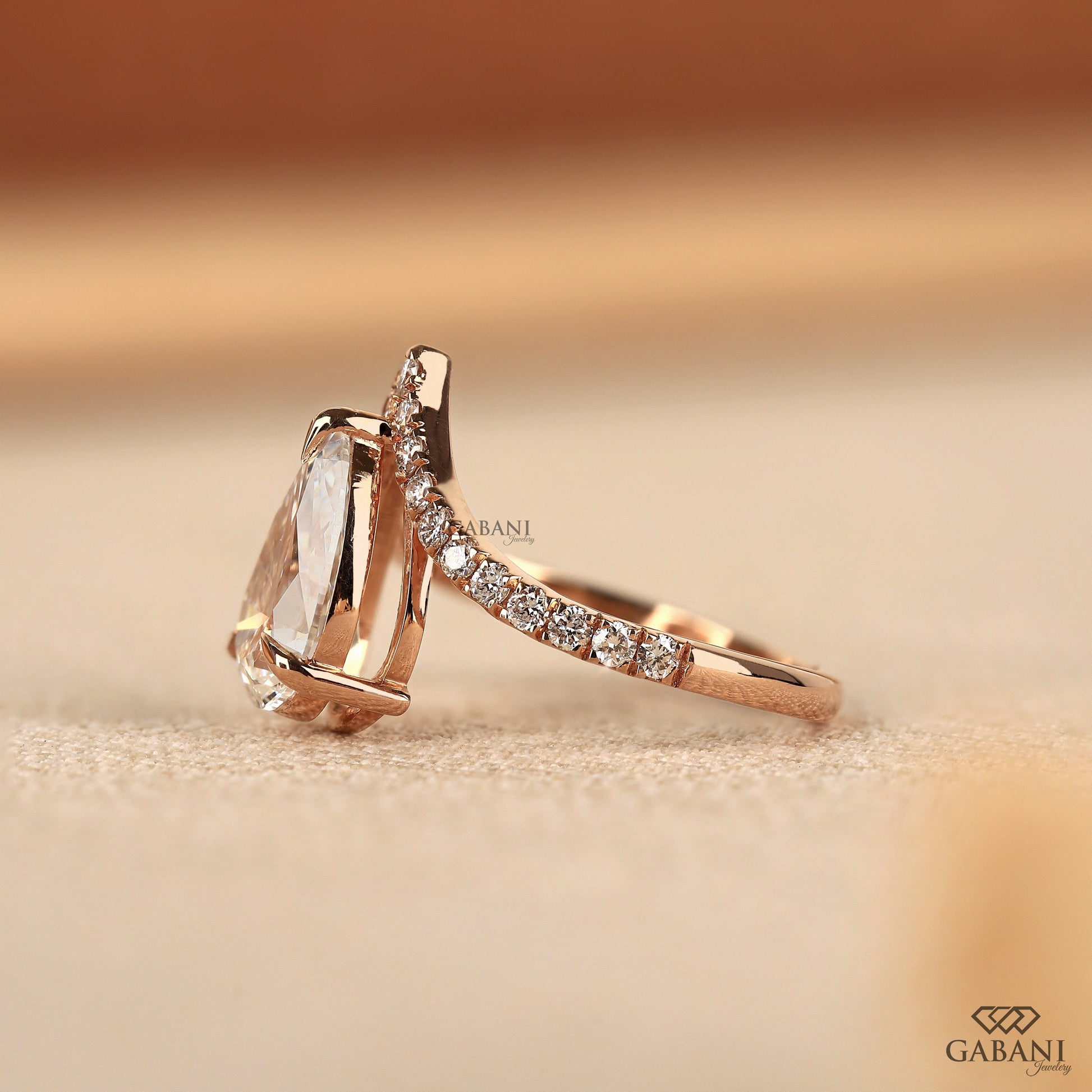 Claw prong pear cut diamond ring with pavé round stones