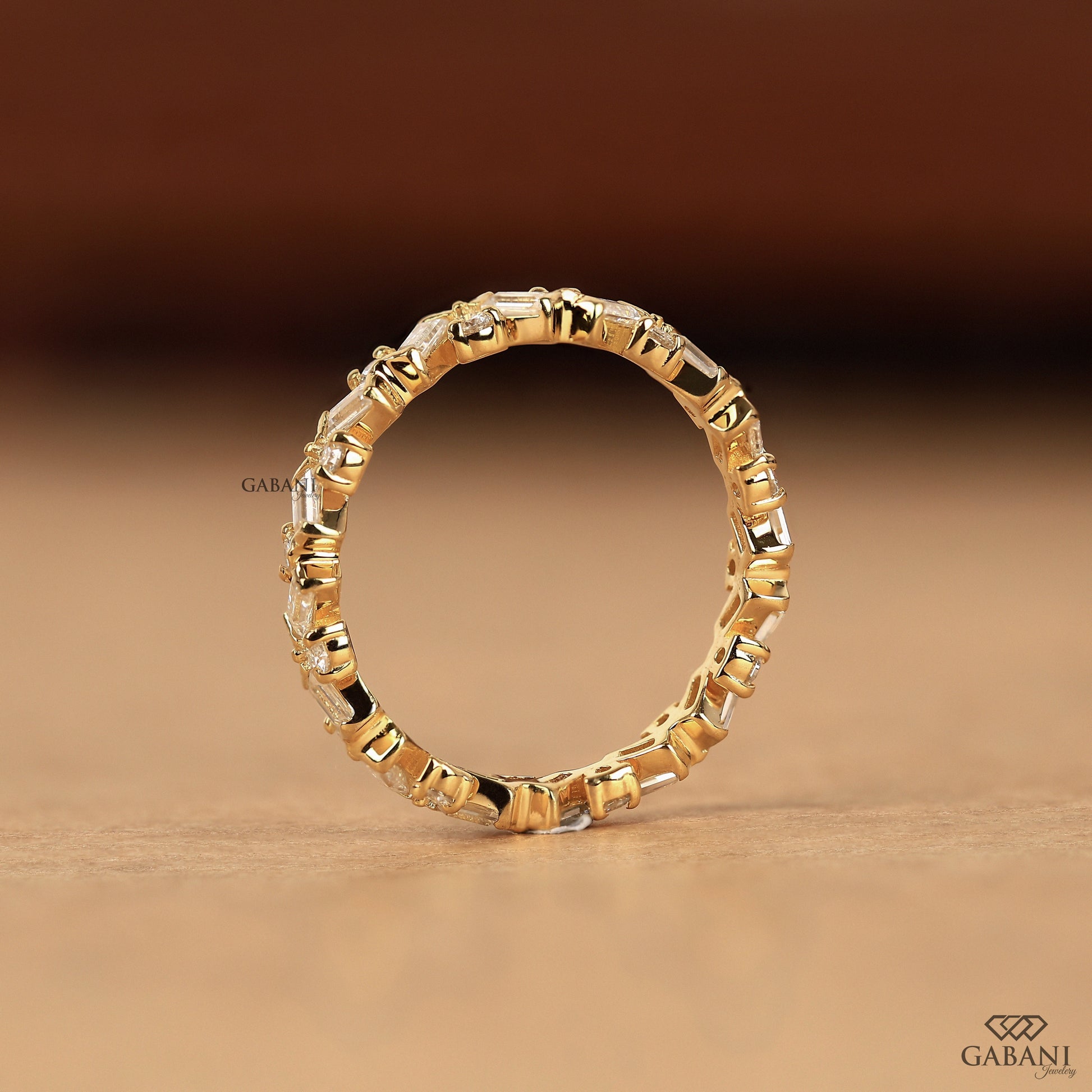 lab grown diamond ring with baguette and round stones in thin zig zag gold band